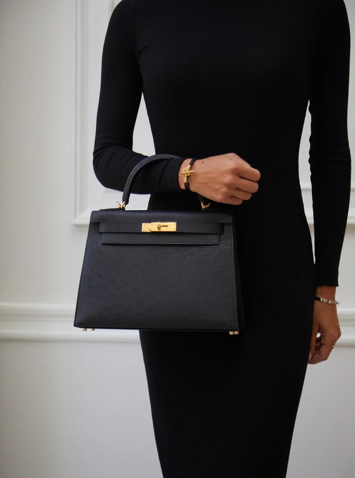 This stunning Hermès Kelly 28 bag is featured in Noir (Black), Ostrich leather and gold hardware, the best combo. Considered one of the strongest leathers, it ages very well and may be wiped down in case of exposure to rain. This luxurious skin