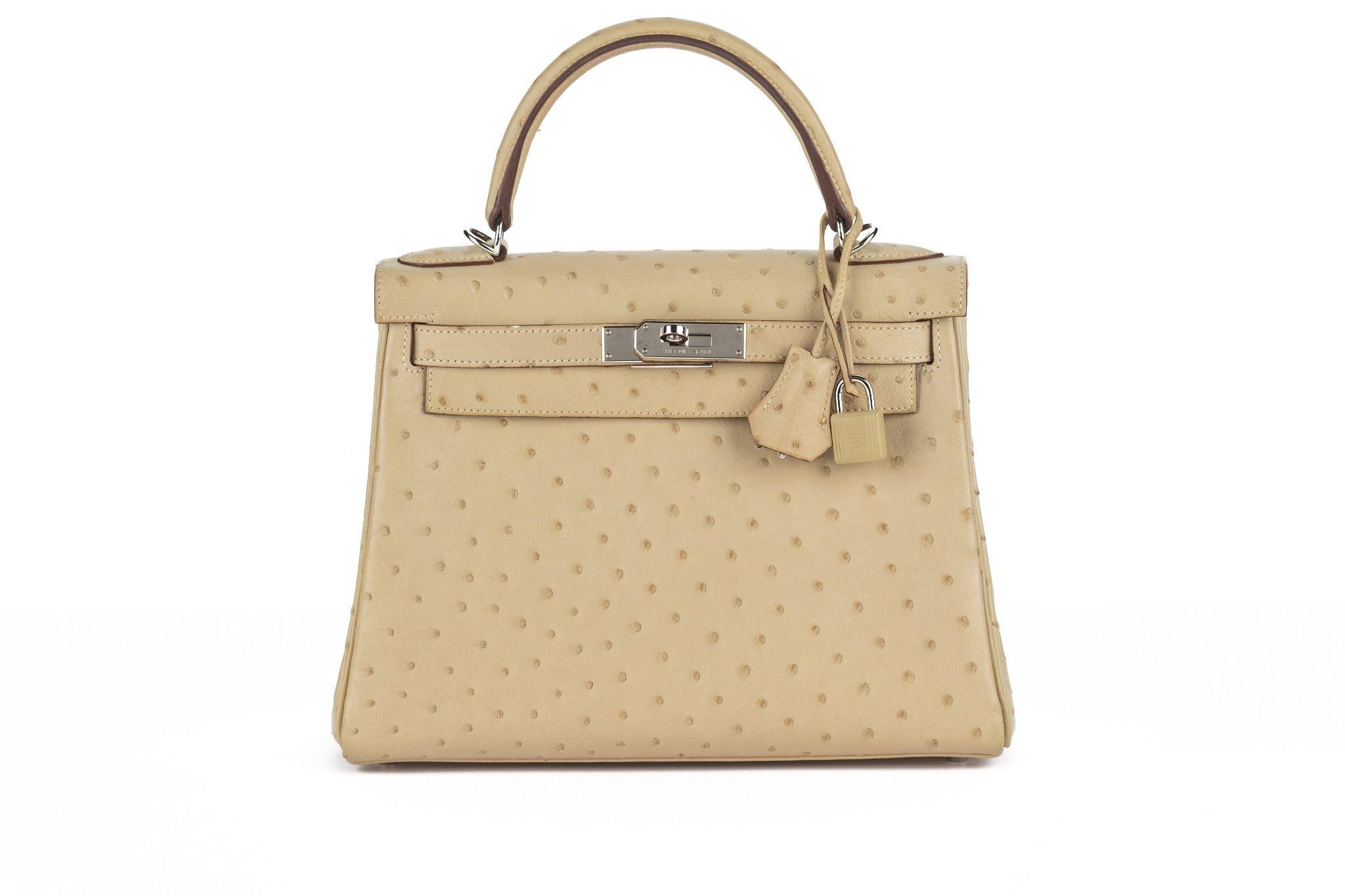 The Kelly 28 retorune ostrich leather in parchemin color with palladium hardware, and tonal stitching, two straps with front toggle closure, clochette with lock and two keys, single rolled handle and removable shoulder strap. The interior is lined