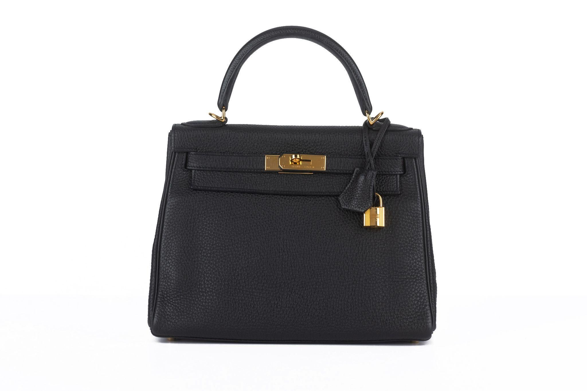 This Hermès Kelly 28 Retourne, in Black Togo leather with gold hardware and tonal stitching, two straps with front toggle closure, a clochette with lock and two keys, a single rolled handle, and a removable shoulder strap. Comes with booklet,