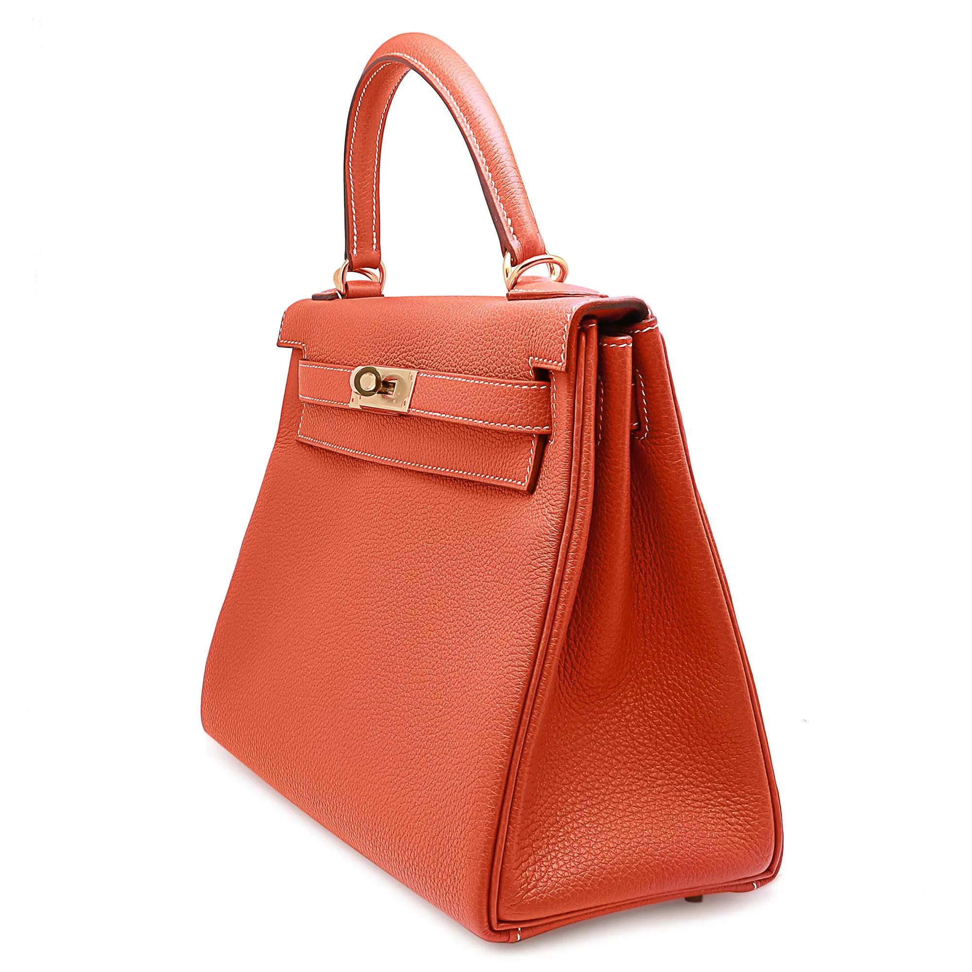Hermes Kelly Retourne 28 Feu Togo Sanguine. This stunning Hermes classic handbag is beautifully crafted in stamped Togo calfskin leather in fire orange with white stitching. Come with a single rolled leather top handle with a detachable leather