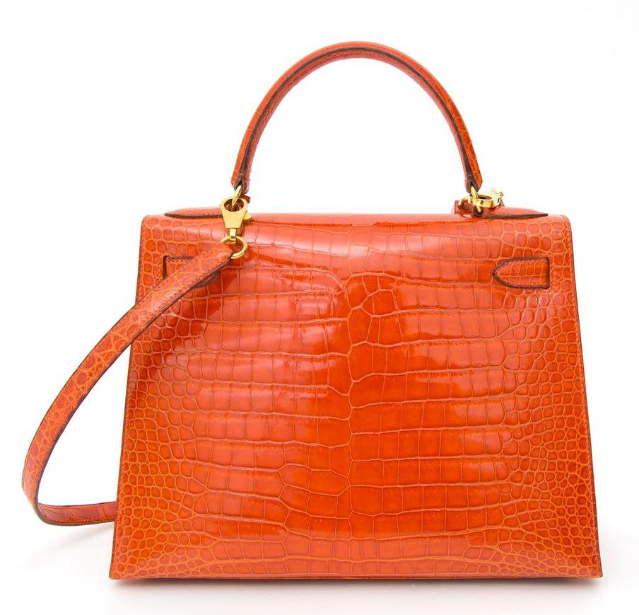 Unseen beauty! This Hermès Kelly bag in precious crocodile Porosus is dyed in one of Hermès' most stunning colors, 'Rouge Agathe'. 
It is a deep burnt orange hue that vibrates through the glossy surface of the Porosus hide and is in perfect accord