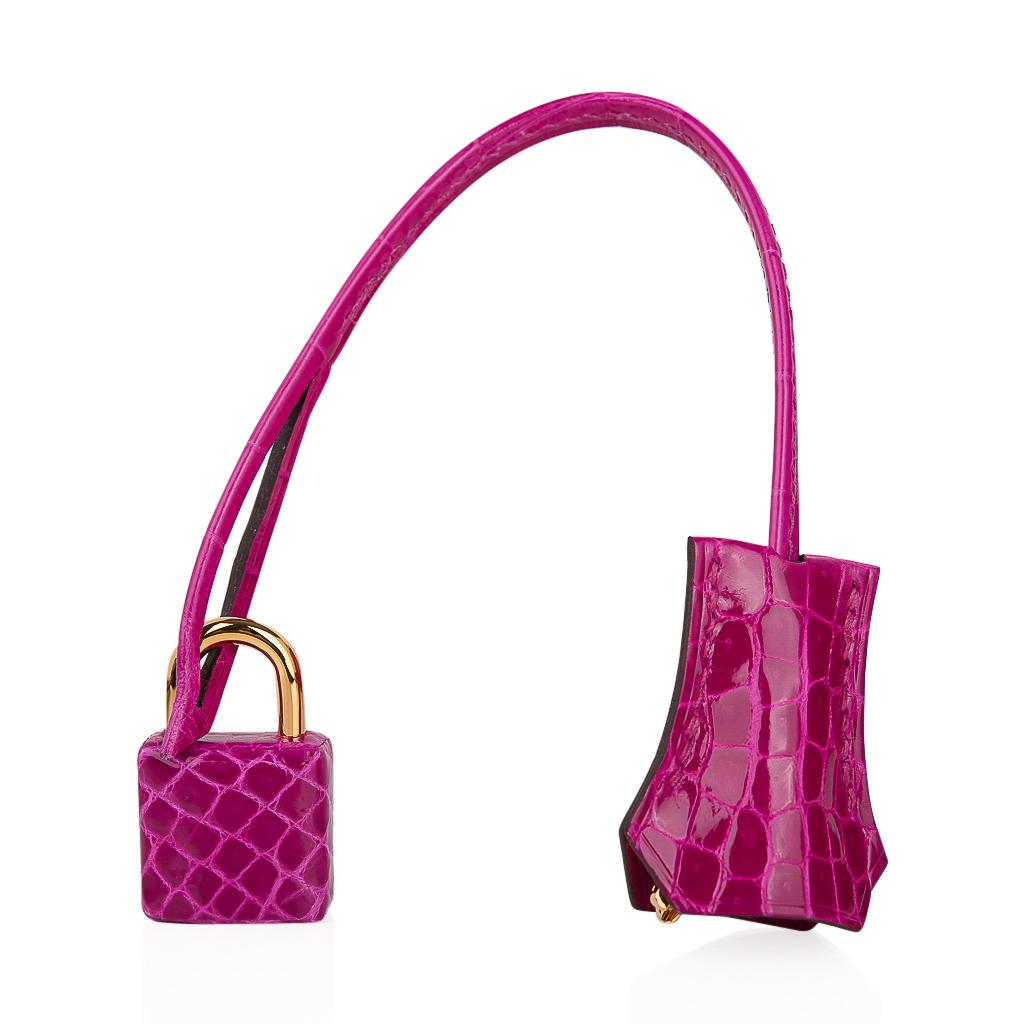 Guaranteed authentic Hermes Kelly 28 bag featured in rich jewel toned Rose Scheherazade Crocodile. 
Please see the same combination Hermes Birkin 30 listed listed in my dealer store, mightychic. 
This iconic pink Hermes bag is timeless and chic.