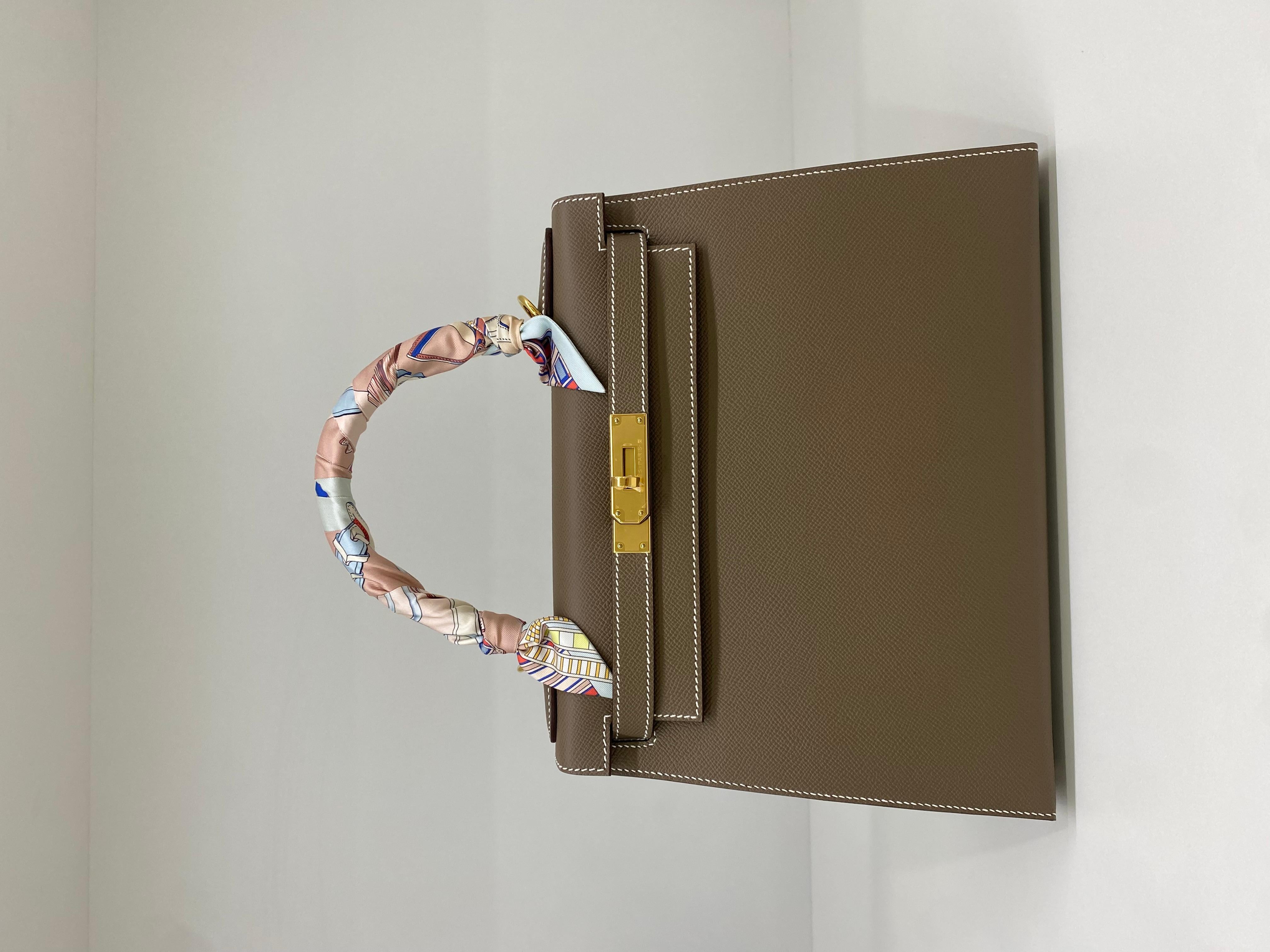 Zustand: Wie neu

- Plastik noch auf den Beschlägen, keine Farbübertragung, keine Flecken auf der Tasche

Farbe: Etoupe

Leder: Epsom

Jahr: B-Stempel (2023)

Farbe der Hardware: Gold

Einschluss: Vollständiger Satz

- Mit abnehmbarem Gurt & Twilly