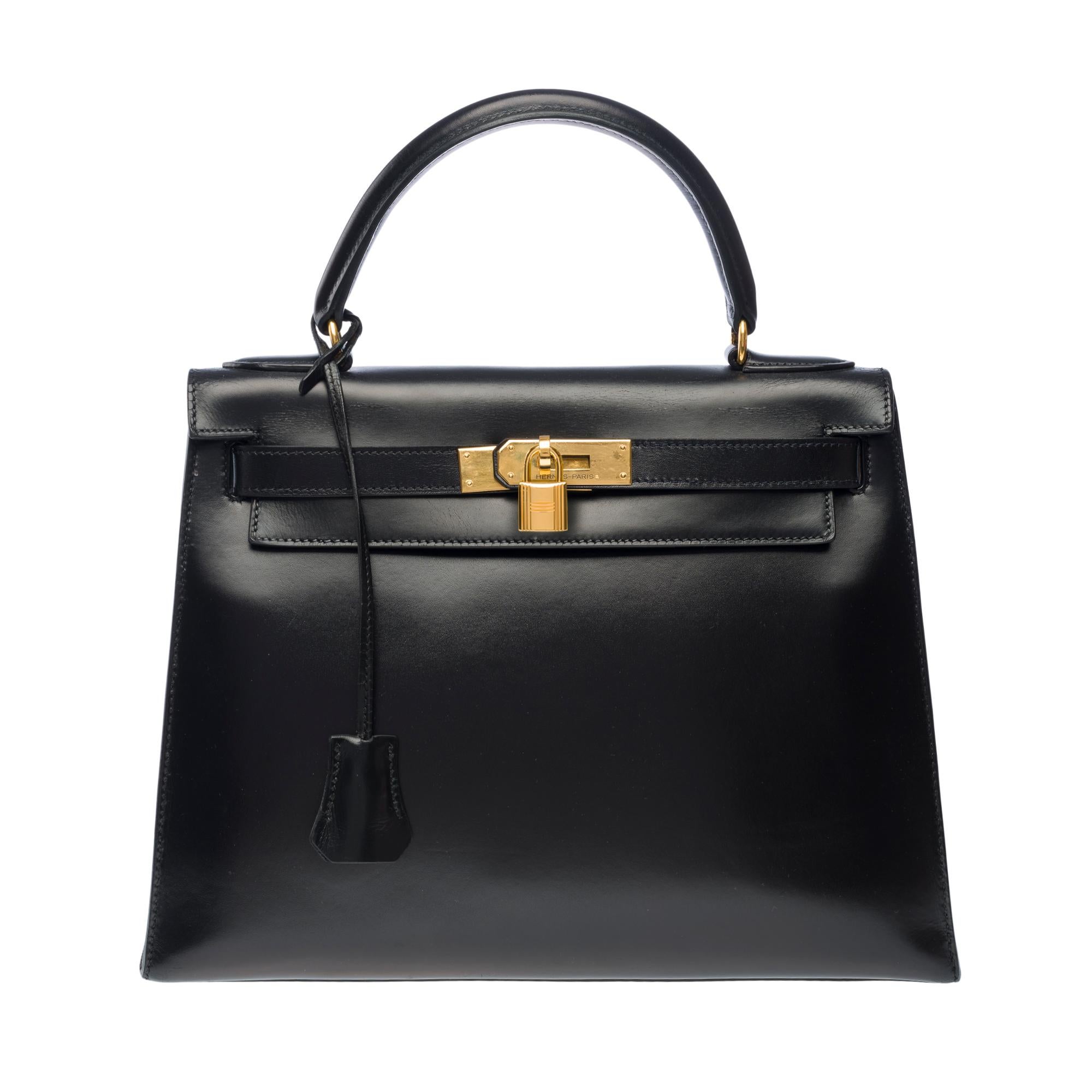 Superb​ ​Hermès​ ​Kelly​ ​28​ ​bag​ ​sellier​ ​in​ ​black​ ​box​ ​calf​ ​leather,​ ​​ ​​ ​gold​ ​plated​ ​metal​ ​trim,​ ​black​ ​leather​ ​box​ ​handle​ ​for​ ​hand​ ​carry

Flap​ ​closure
Black​ ​leather​ ​inner​ ​lining,​ ​​ ​​ ​one​ ​zippered​