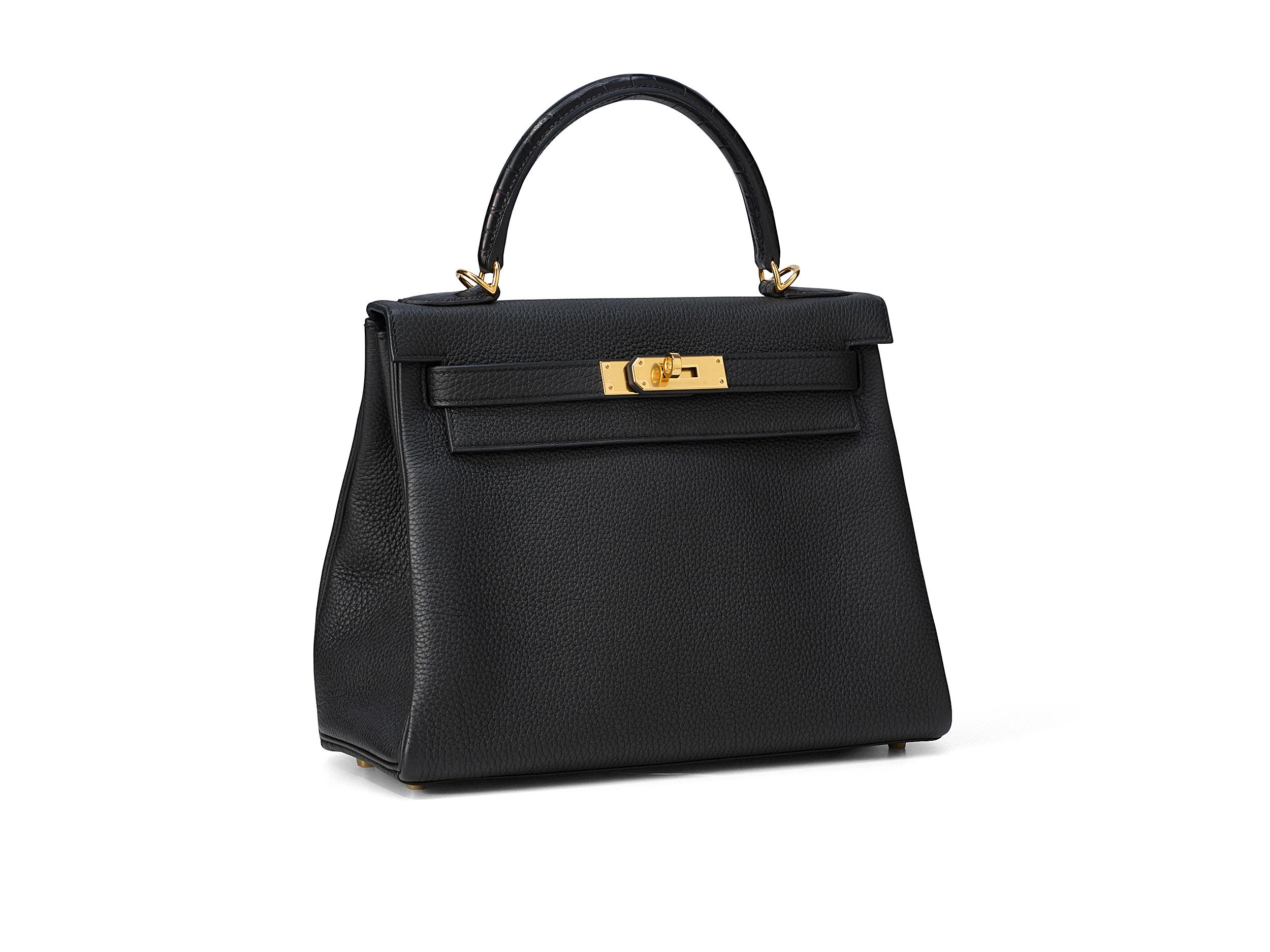 Hermès Kelly 28 aus schwarzem Alligatorleder mit goldenen Beschlägen. Die Tasche ist ungetragen und kommt als komplettes Set inklusive der Originalquittung und Cites.

Stempel C (2018) 

