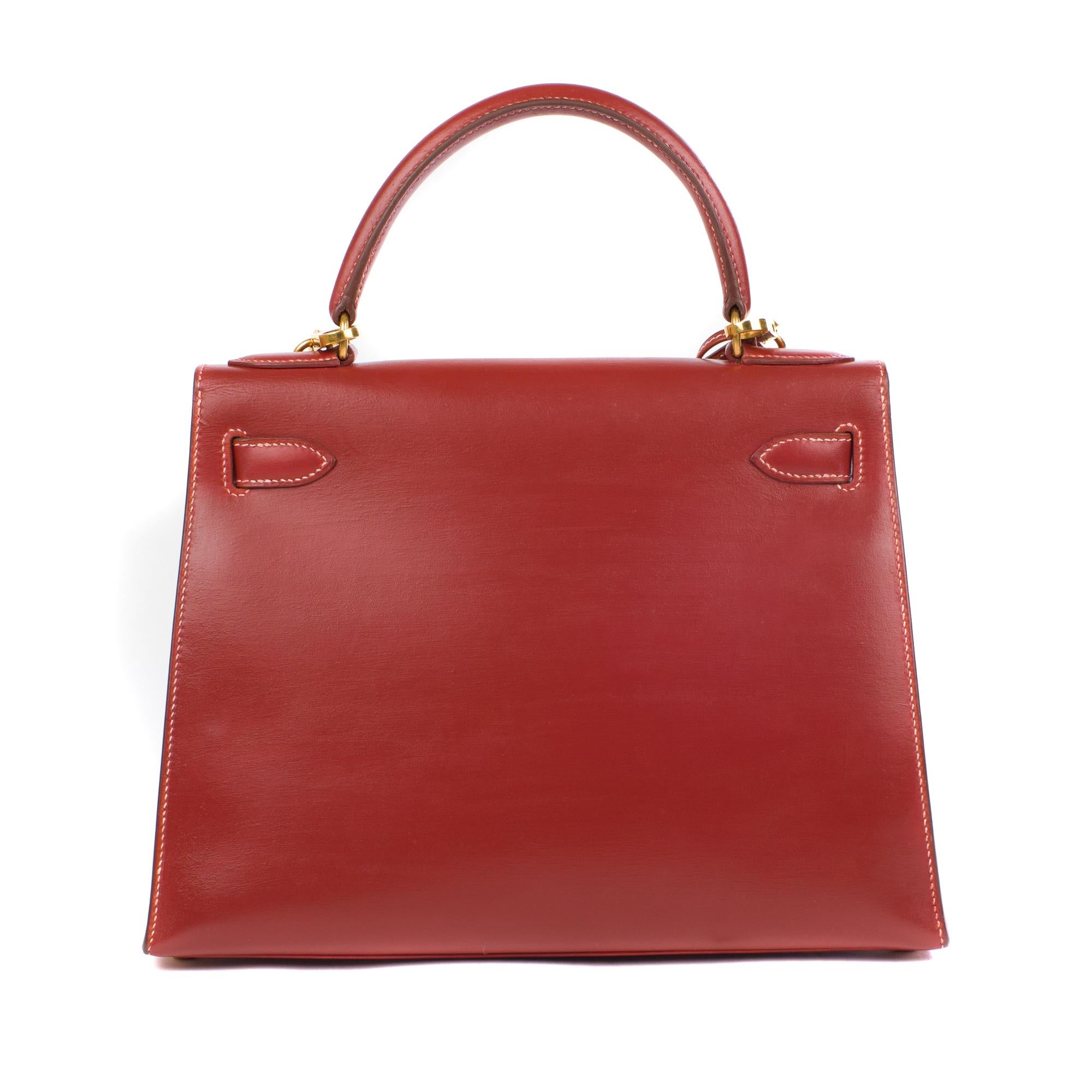 Stunning and rare Hermès Kelly 28 with saddle stitching in red brick leather, gold-plated metal hardware, white saddle stitching, red brick leather handle, shoulder strap in red brick leather for hand or shoulder wear. Flap closure. Inner lining in