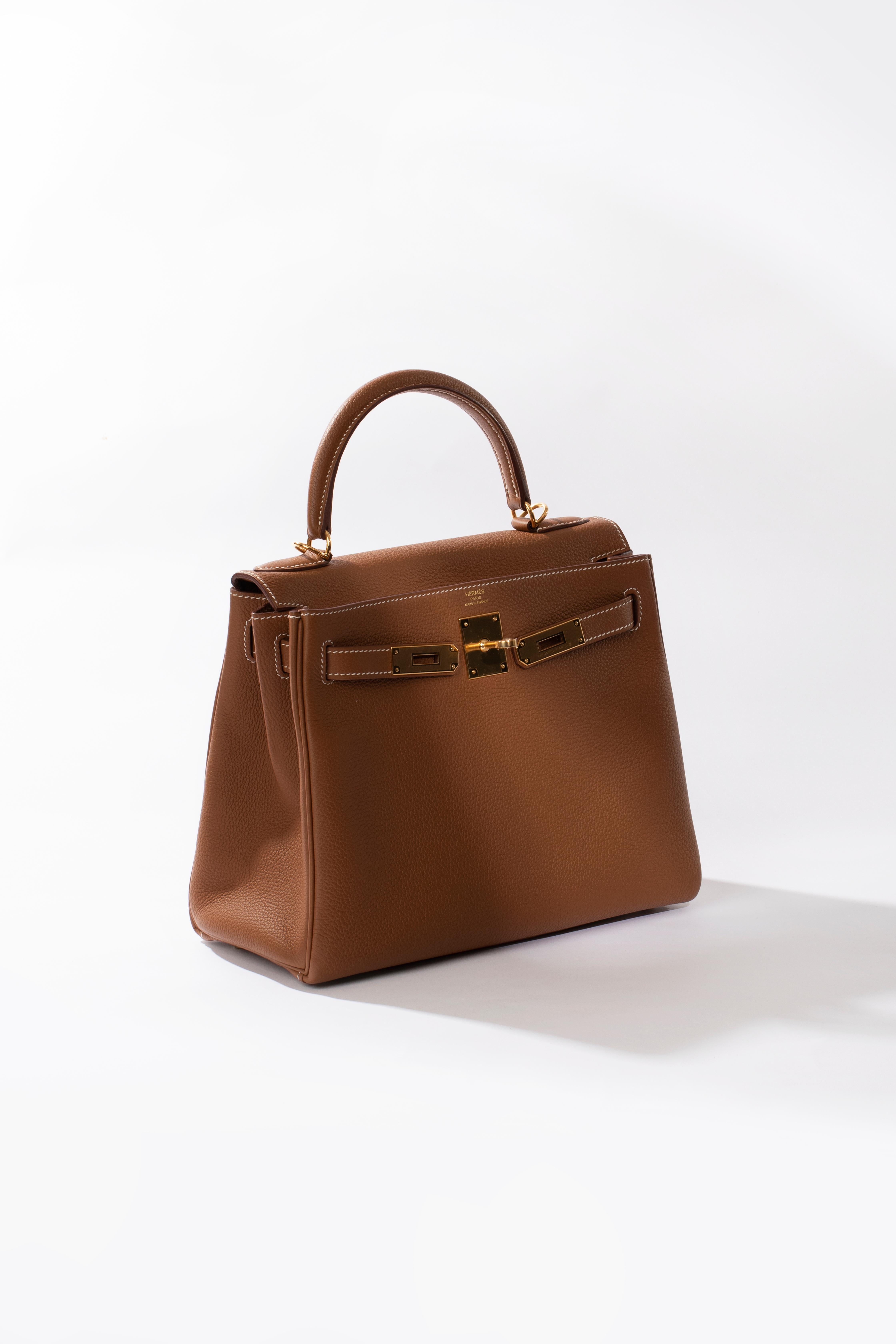 Brand: Hermès 
Style: Kelly Retourne
Size: 28cm
Color: Gold
Leather: Togo
Hardware: Gold
Stamp: 2021 Z

Condition: Pristine, never carried: The item has never been carried and is in pristine condition complete with all accessories.

Accompanied by: