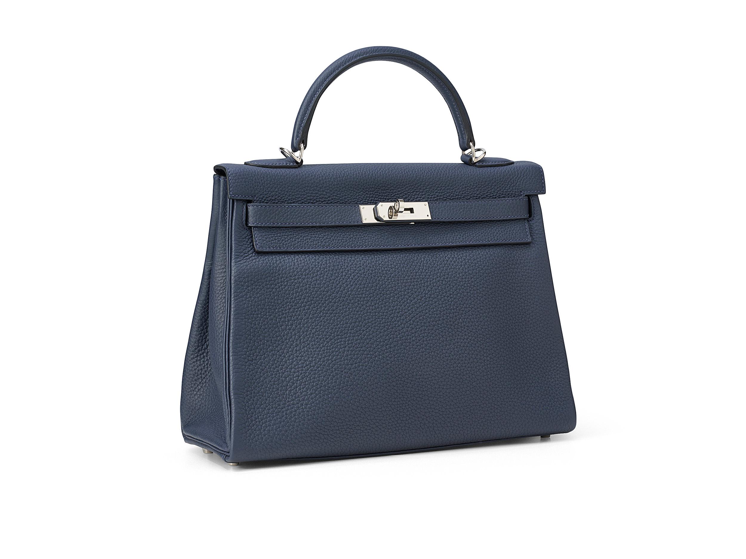 Hermès Kelly 32 en cuir bleu nuit et togo, avec des accessoires en palladium. Le sac est en excellent état avec des rayures mineures sur la quincaillerie et est livré en set complet incluant le reçu original.

Timbre Y (2020) 

