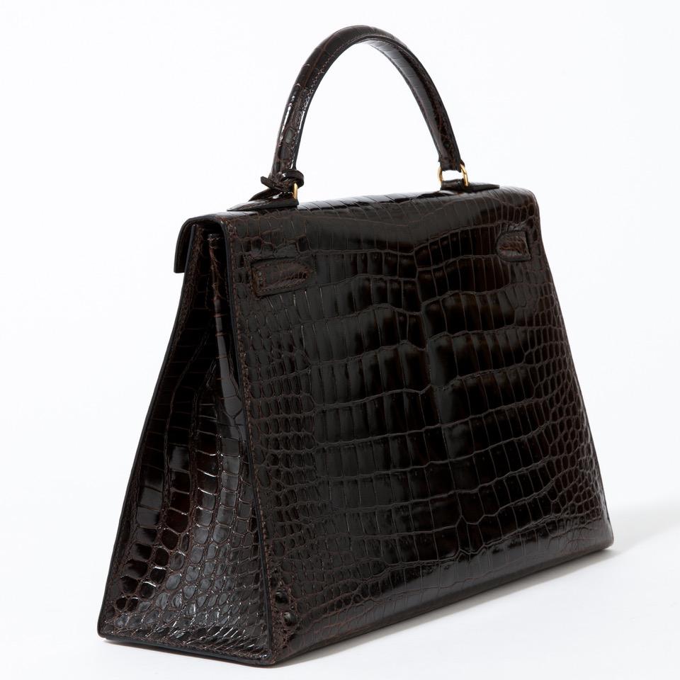 Sublime handbag Hermes Kelly 32 cm crocodile porosus fawn brown trim gold metal, Saddle stitches, single handle crocodile porosus fawn brown to a hand port.

Closure flap.
lining brown leather, a zip pocket, a double pocket.
Sold with zipper, key,