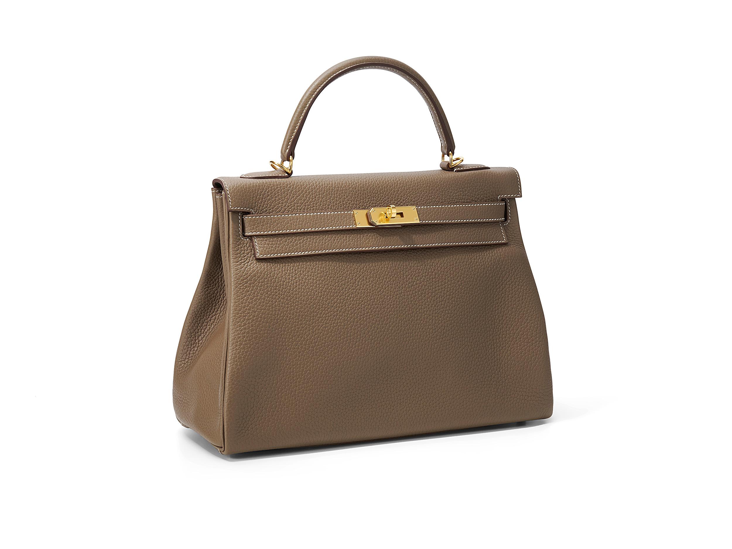 Hermès Kelly 32 in etoupe and taurillon clemence leather with gold hardware. The bag is unworn but has a minor scratch on one corner at the bottom and comes as full set.

Stamp Y (2020) 

