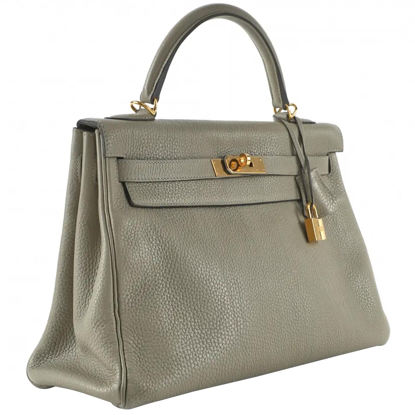 Featuring a single top handle, front flap, and Kelly “Twist-Lock” clasp with engraved branding. There is one main compartment and one flat pocket with a gold-tone brand signature, with a removable crossbody strap, padlock,  clochette, and key