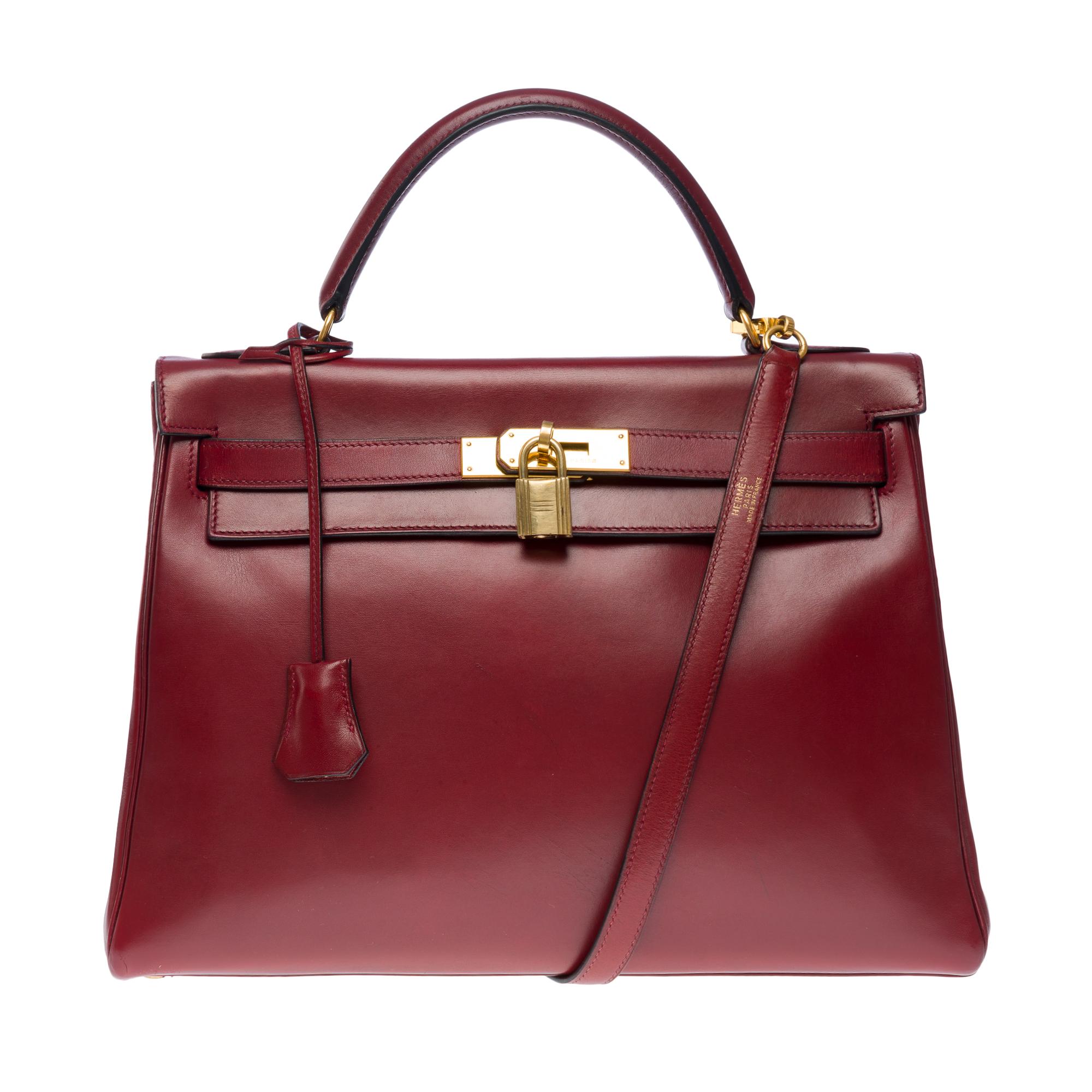Gorgeous Hermes Kelly 32 retourne handbag strap in Rouge H (burgundy) box calf leather , gold plated metal trim, burgundy leather handle,   removable shoulder strap in burgundy leather for hand or shoulder carry

Flap closure
Inner lining in