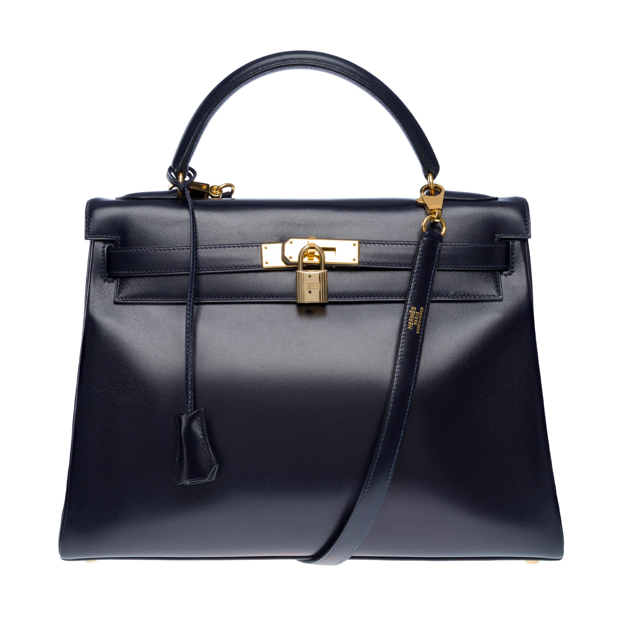 Hermes​ ​Kelly​ ​32​ ​retourné​ ​handbag​ ​strap​ ​in​ ​navy​ ​blue​ ​calf​ ​box​ ​leather,​ ​gold​ ​plated​ ​metal​ ​hardware,​ ​navy​ ​blue​ ​calf​ ​leather​ ​handle,​ ​removable,​ ​navy​ ​blue​ ​strap​ ​allowing​ ​hand​ ​or​ ​shoulder or​