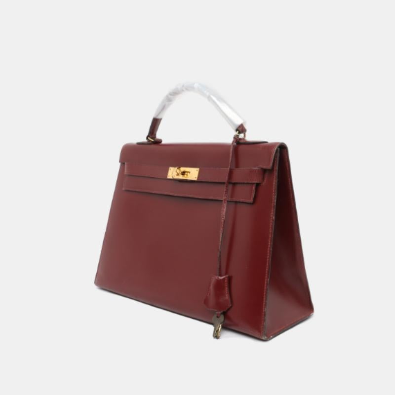 Hermes Kelly 32 Sellier Burgundy Box Leather Gold HW 1987
 These are professional photos of the actual bag.
 Condition: Good condition.
 Overall signs of use. Scratches on leather and hardware. Light stains on the inside. Cracks on the flap. 
