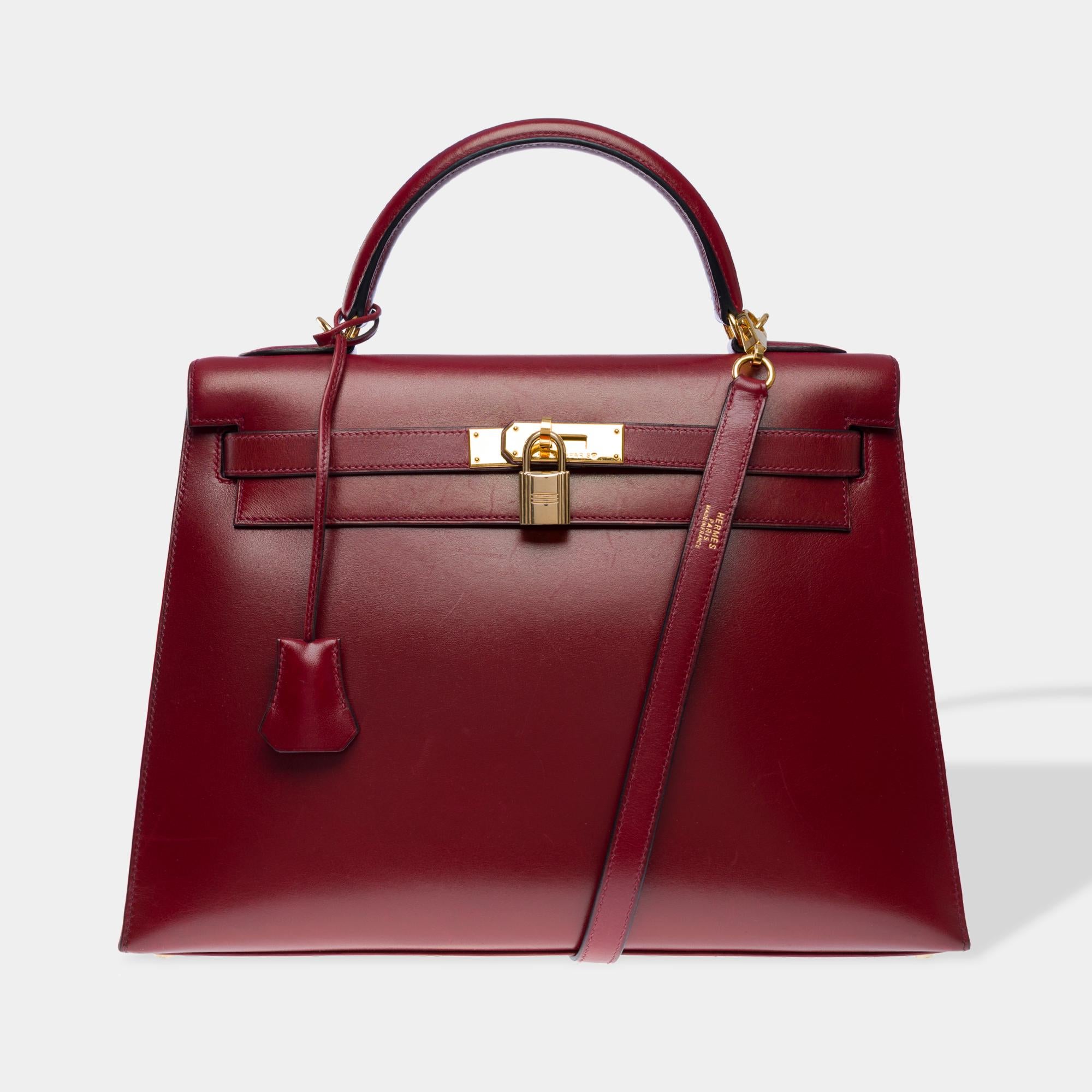 Superb Hermes Kelly 32 Sellier handbag strap in Rouge H (Bordeaux) box calf leather,  gold metal trim, removable red box calf leather shoulder strap, single red box calf leather handle for hand or shoulder carry

Flap closure
Red leather interior