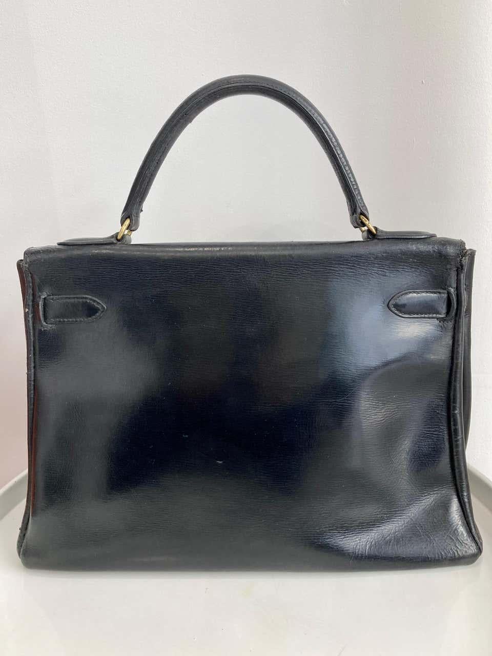 1960's Hermès black box calf leather Kelly 32 tote bag featuring a foldover top with push-lock closure, a top handle, plated gold-tone hardware and an internal pockets. 
Marked Hermes Paris
In fair vintage condition ( see the top part aged). Made in