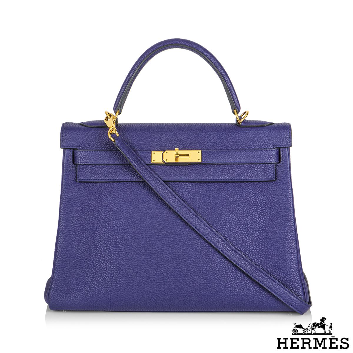 A gorgeous Hermès Kelly 32cm Bleu Encre handbag. The exterior of this Kelly features bleu veau togo leather with gold tone hardware. It has a front toggle closure, a single rolled handle, and tonal stitching. The interior is lined with bleu veau