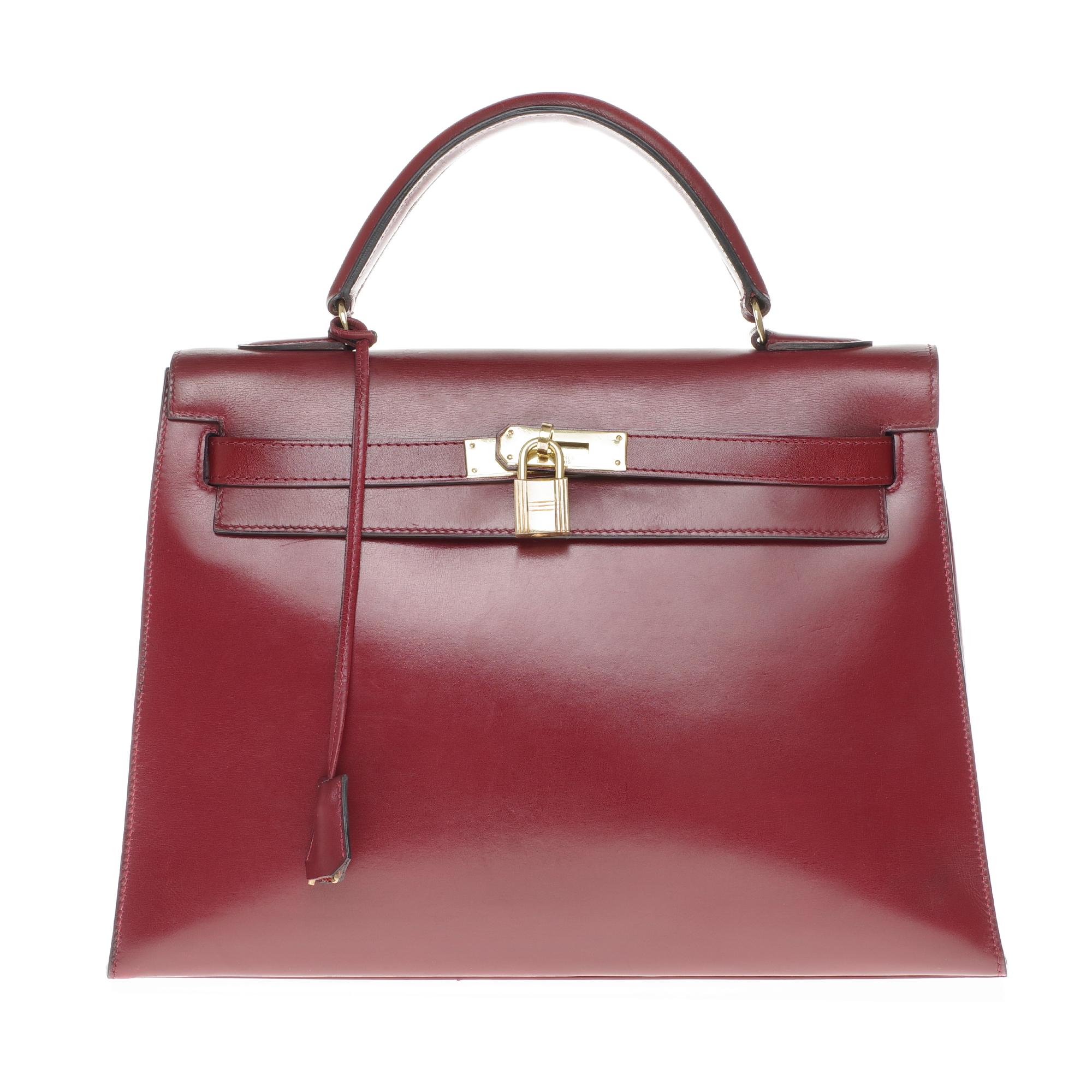 Beautiful Hermes Kelly 32 saddle bag in burgundy calfskin leather box , gold plated metal trim, removable shoulder strap in red leather box H (not signed Hermès), single handle in red leather allowing a handheld or shoulder strap .
Closure by