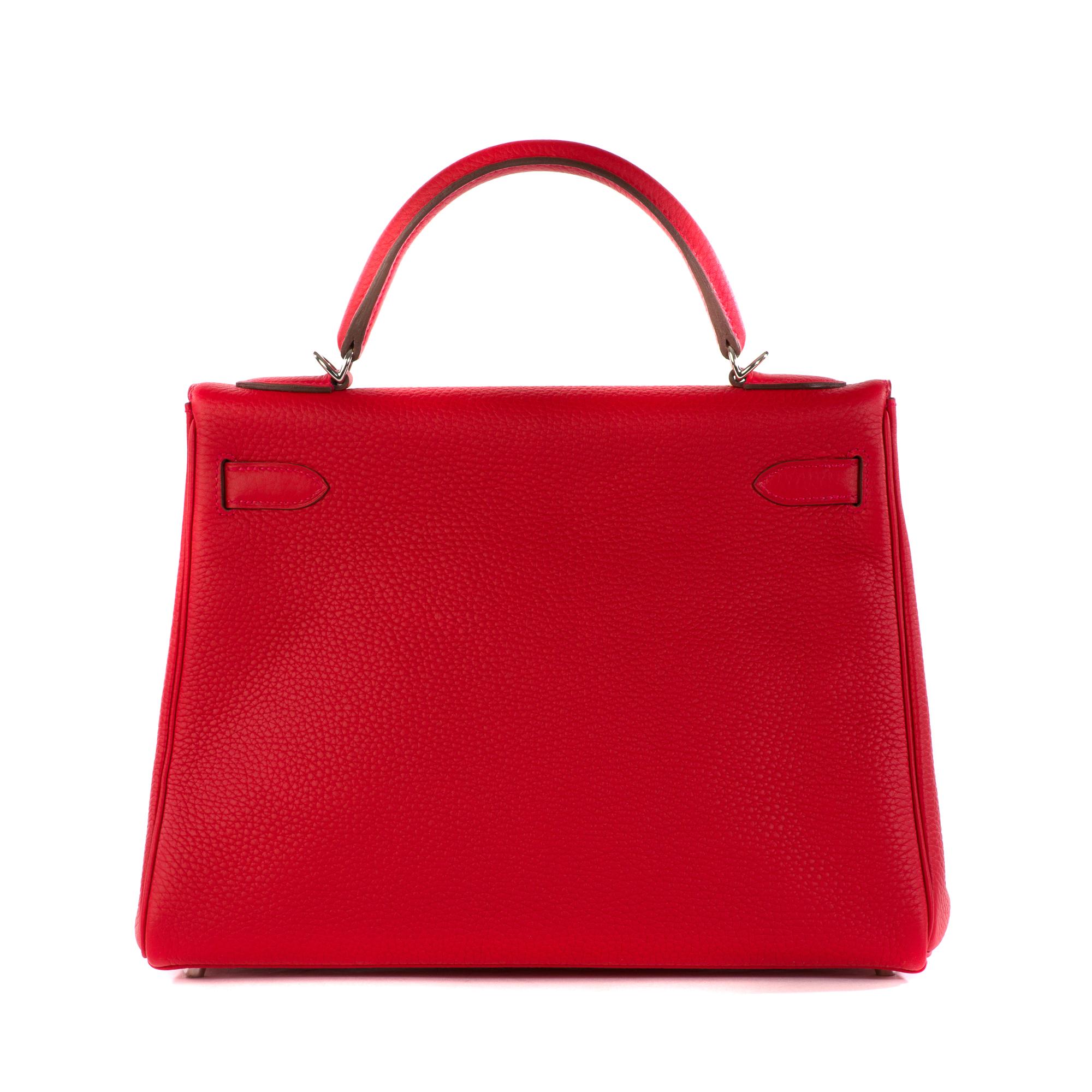 This iconic and classic tote is crafted of beautifully textured Togo leather in red Rouge casaque. The bag features a sturdy rolled leather top handle with palladium silver links, an optional shoulder strap with silver clasps, and a crossover flap