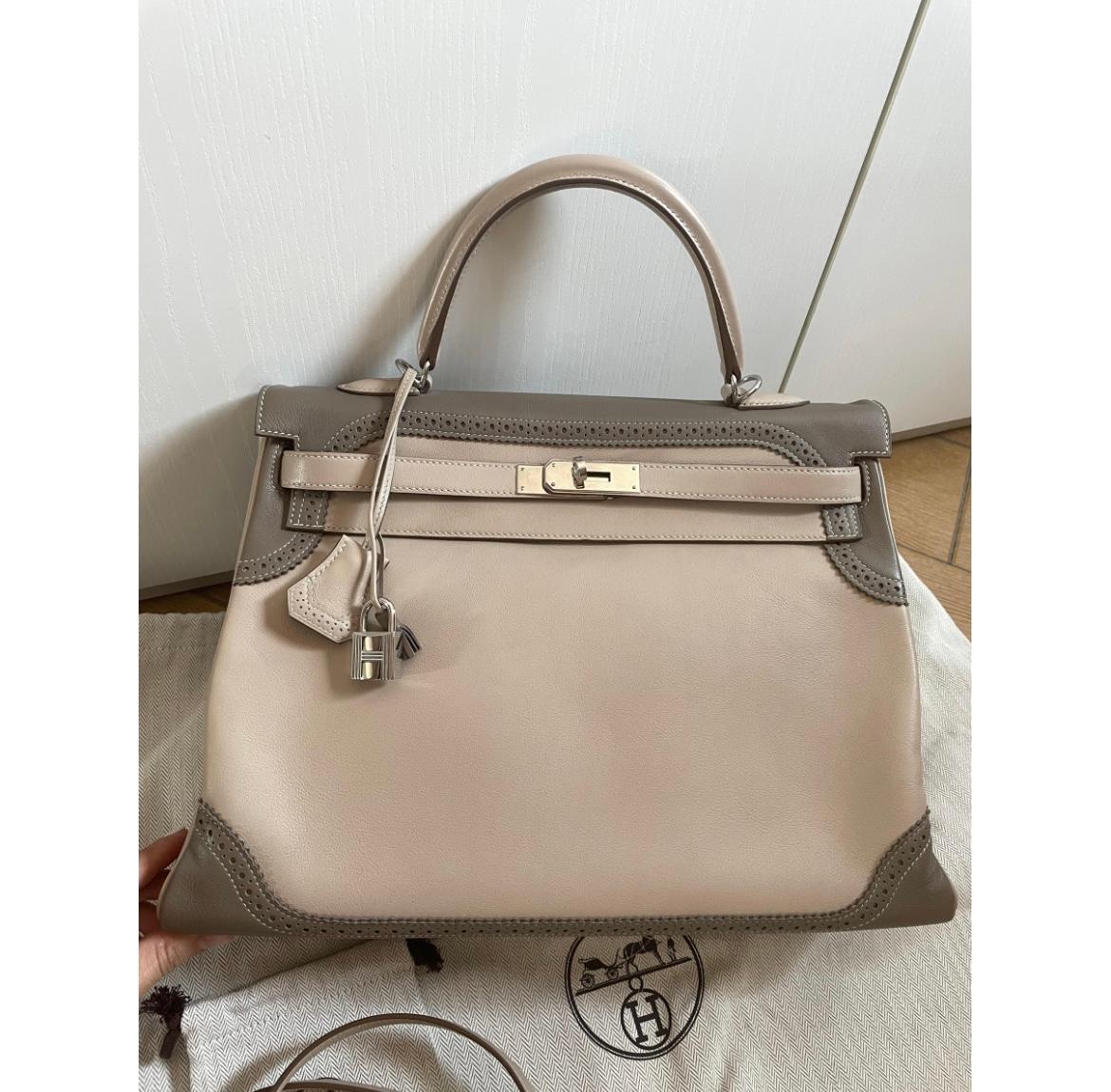 HERMÈS Kelly 35 is in Etoupe body with Argile trim and palladium hardwar. Opens to a leather- lined interior. A limited edition style Ghillies makes it very special to add to ones collection.

Includes invoice, padlock, keys, cloche, shoulder strap,