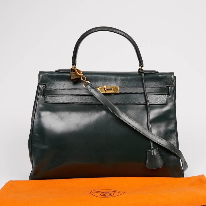 The essential Kelly 35 bag from Maison Hermès in green box leather. The jewelry is made of gold metal. It will be delivered with its padlock, zipper, bell and keys. It can be carried in the hand as well as on the shoulder using a removable strap.
It