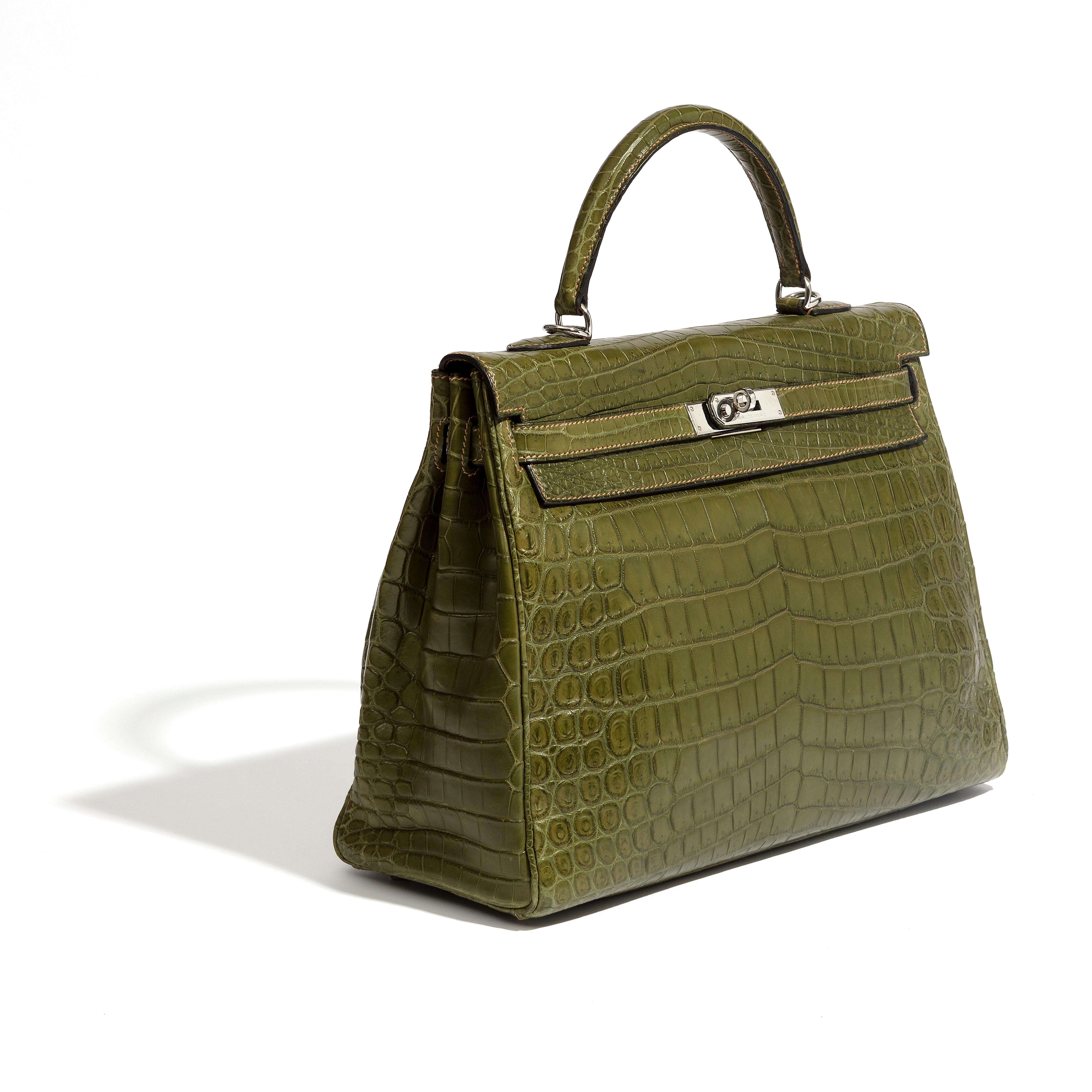 Ce sac d'occasion Kelly 35 Green Niloticus, l'un des modèles les plus recherchés d'Hermès, a été réalisé en cuir de crocodile vert kaki. Un véritable témoignage de la qualité de l'artisanat de la maison. 

* Poignée supérieure 
* Quincaillerie en