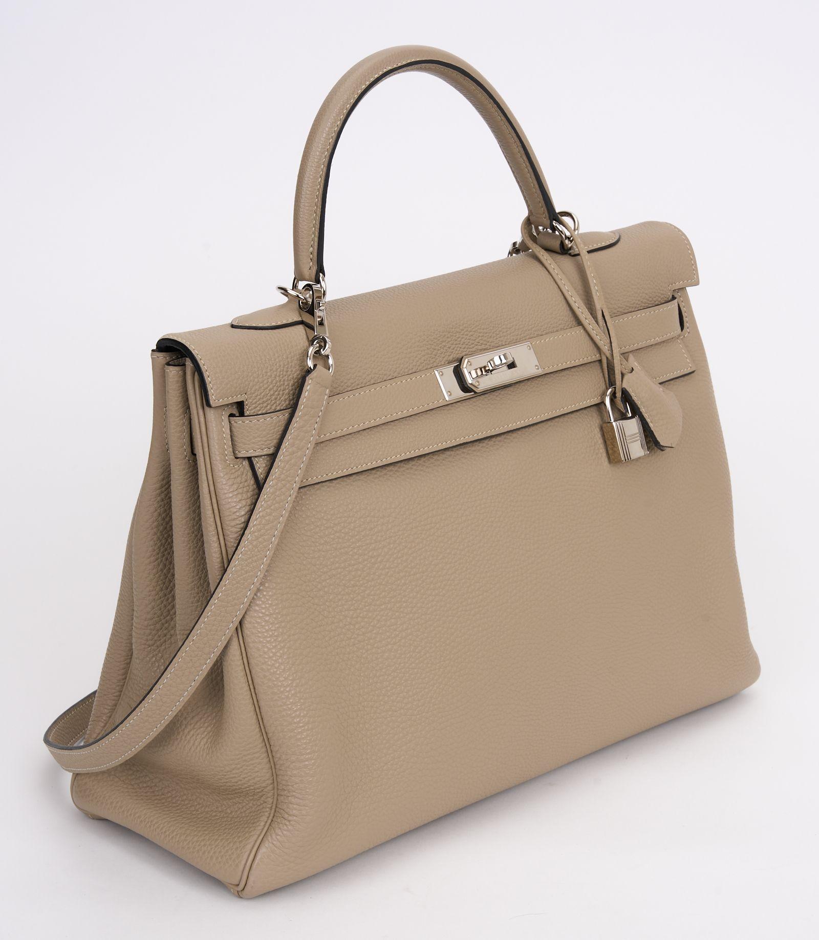 The Hermès Kelly 35 is in the Retourné style, gris tortorelle togo leather with palladium hardware, and has tonal stitching, two straps with front toggle closure, and a single rolled handle, the interior is lined with chevre leather. Comes with the