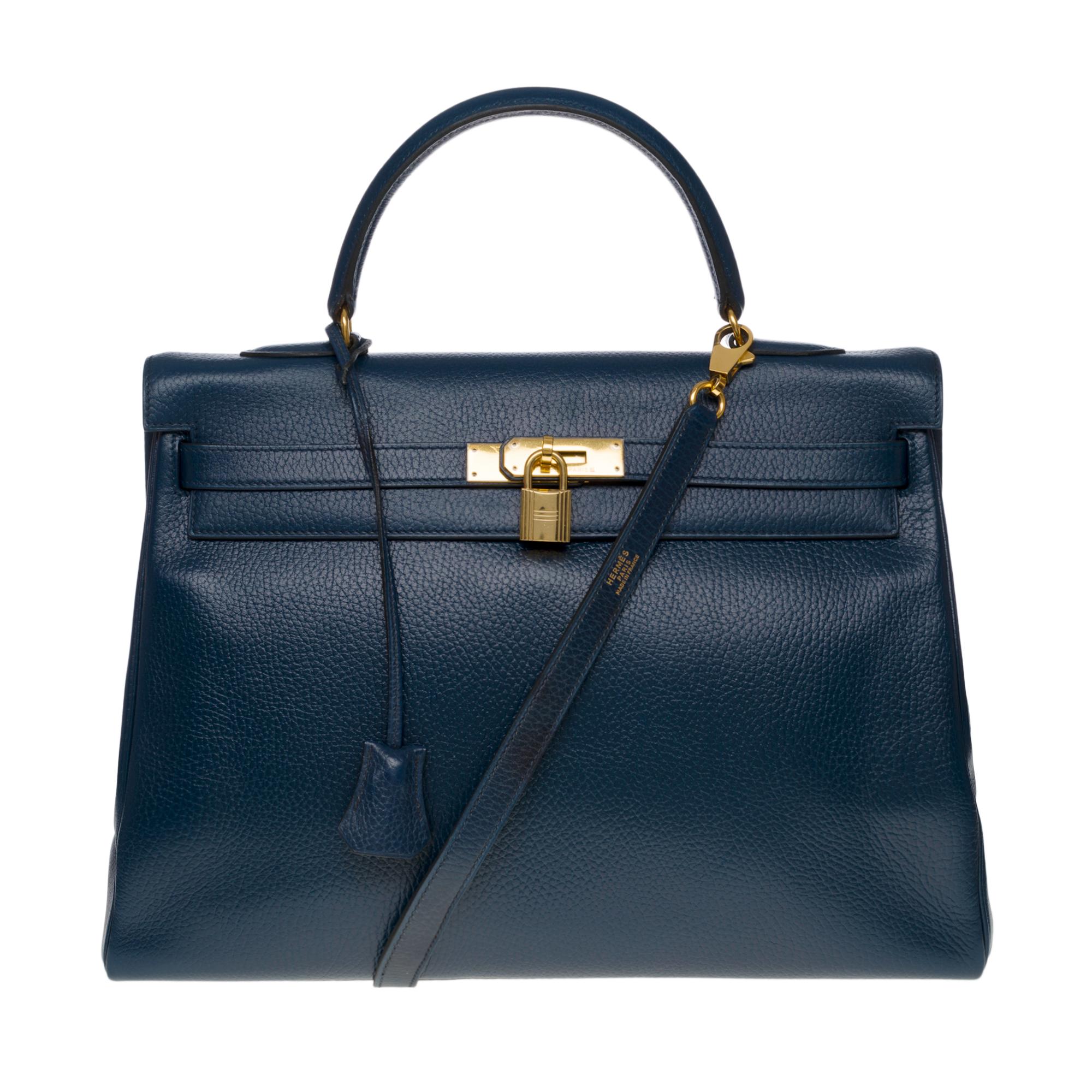 Exquisite Hermes Kelly 35 retourne handbag strap in Blue indigo Vache Ardenne leather, gold plated metal hardware, blue leather handle, removable shoulder strap in blue leather allowing a hand or shoulder support

Flap closure
Inner lining in blue