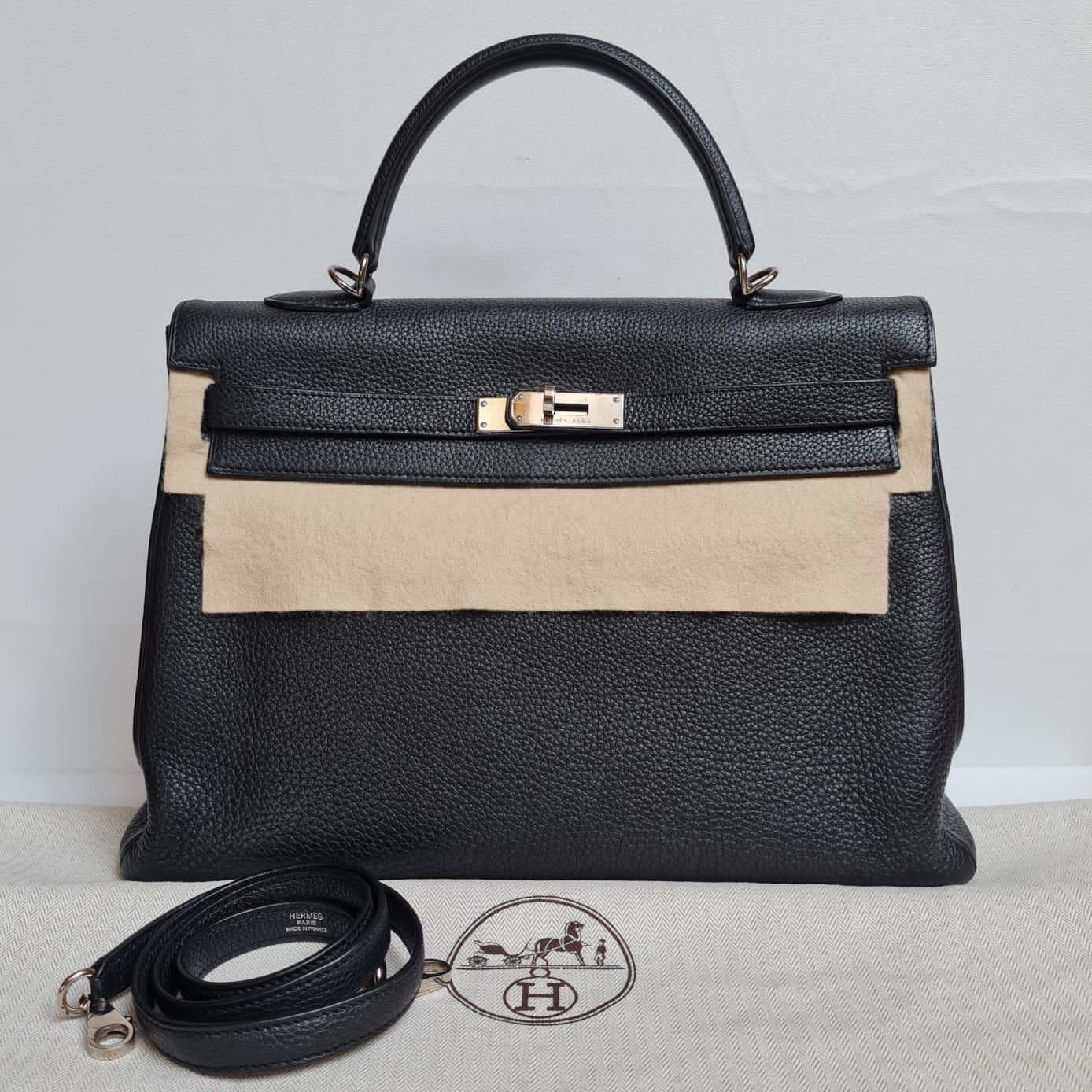 Classic black togo leather kelly 35 bag with palladium hardware. Beautiful statement piece for everywhere wear. Some touch ups on the handle pipeline has been professionally done. Stamp square N. Comes with its strap and dust bag. Missing its