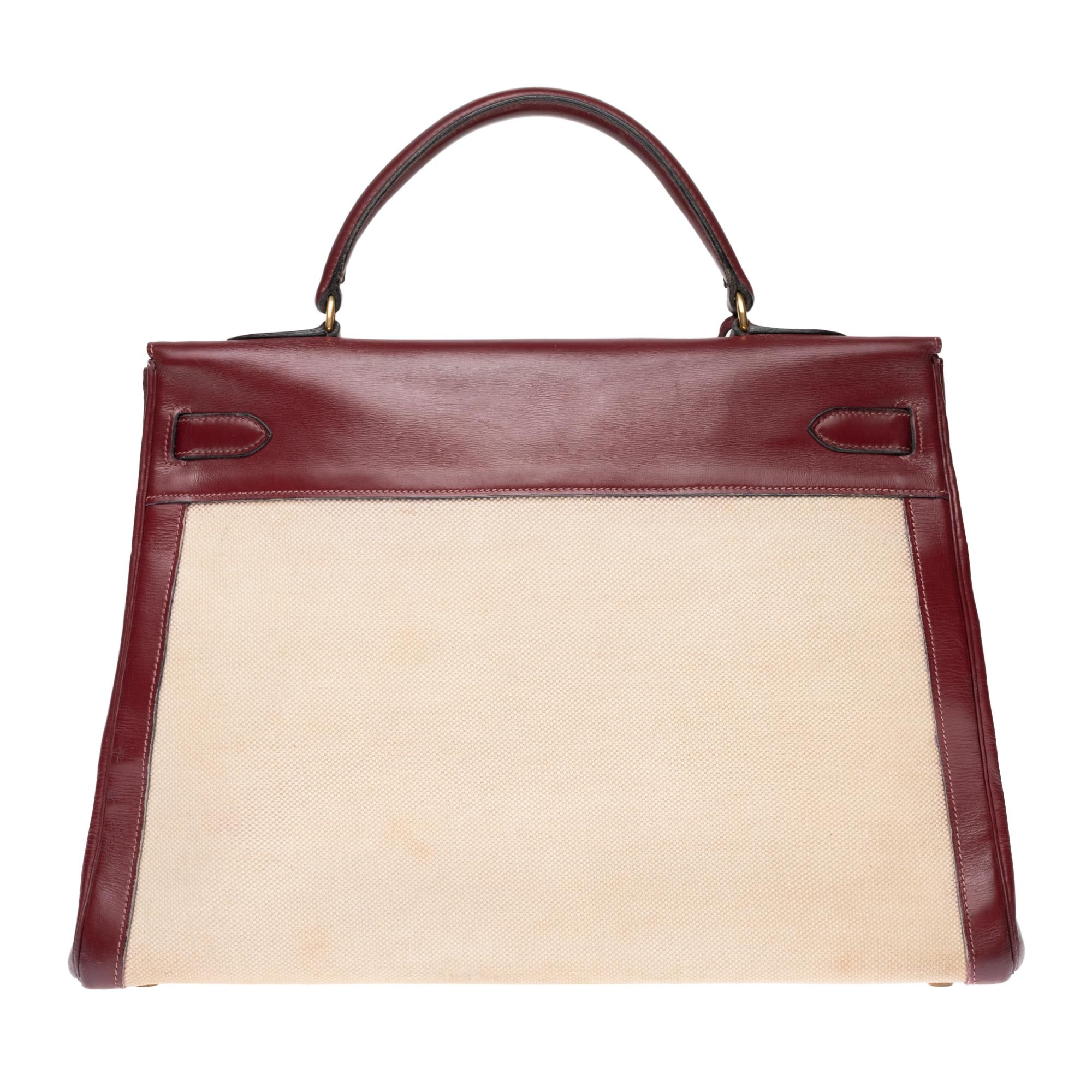 Charming Hermes Kelly handbag 35 cm bi-material in burgundy calf box leather and beige canvas, gilded metal trim, burgundy leather handle allowing a handheld.

Closure by flap.
Interior lining in burgundy leather, a large veneered pocket, a double