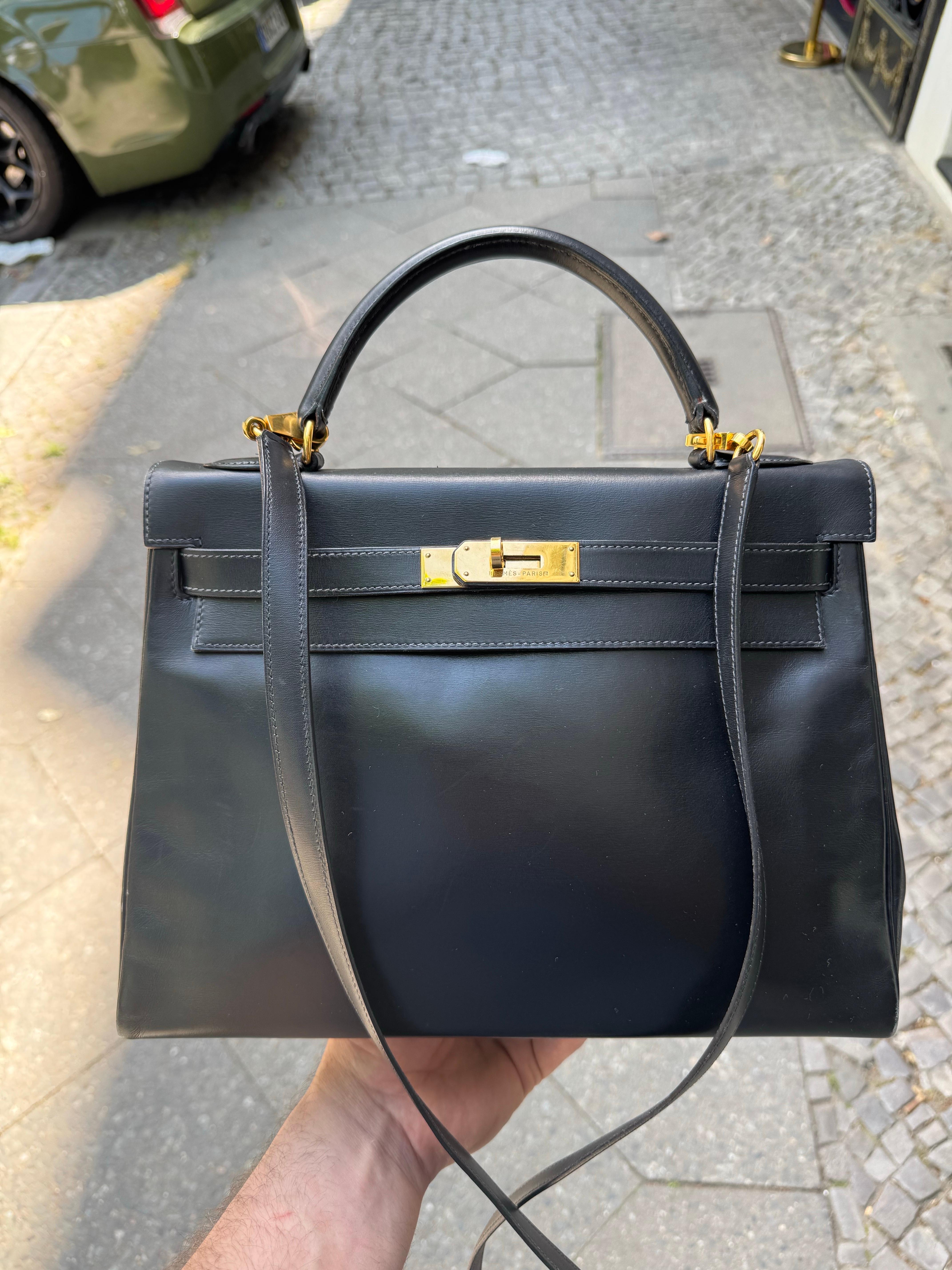 Hermes Kelly Bag 32 aus schwarzem Leder mit goldenen Beschlägen. Die Tasche stammt aus dem Jahr 1993. Sie ist in ausgezeichnetem Zustand, mit Ausnahme der Ecken, die auf Wunsch von einem Handtaschen-Stylisten repariert werden können. Der