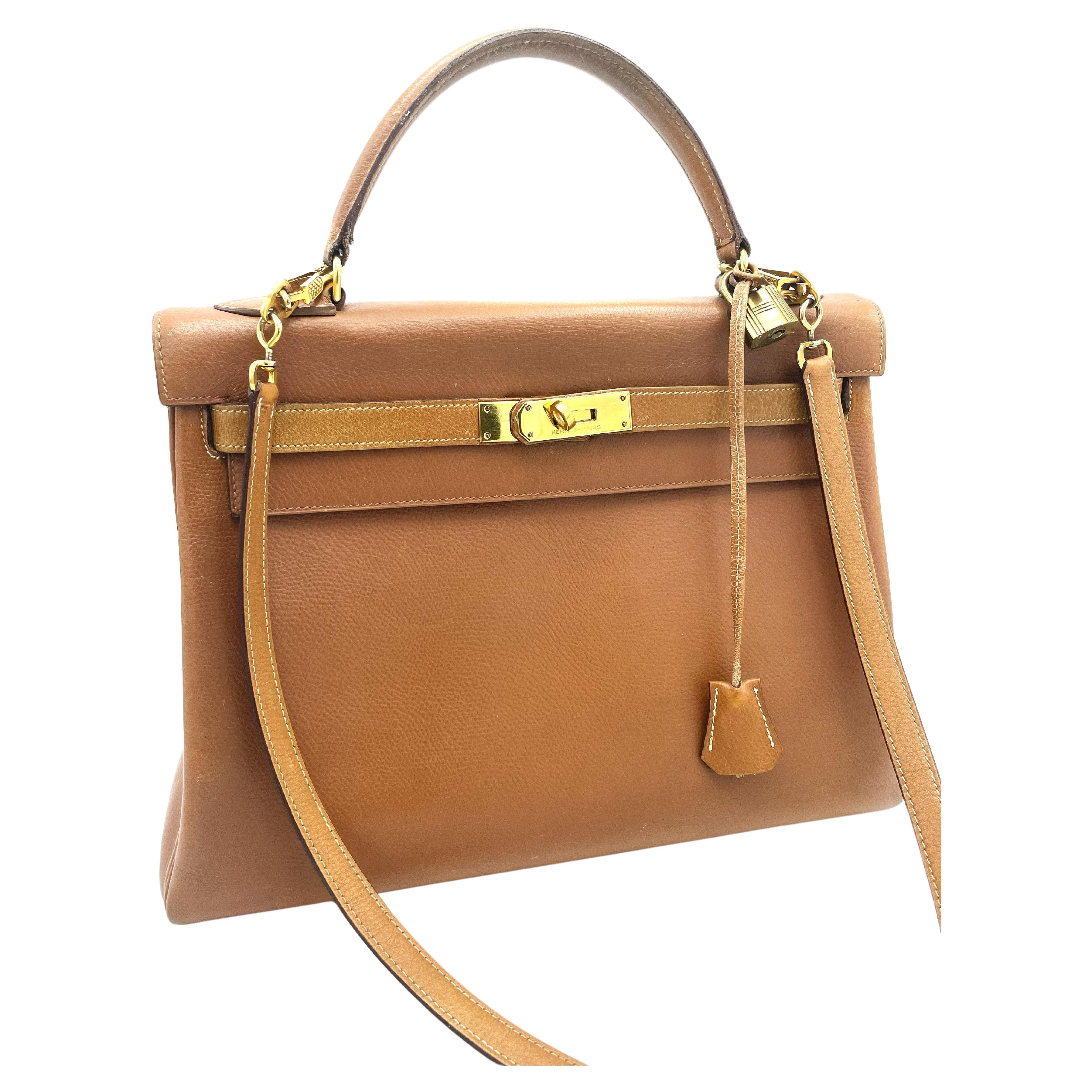 Hermés 2 way Kelly bag, Retourne, 32 cm, Curchevel leather in gold, Collection L in circle = 1982 with long autentic Strap, Lock and Key and Hermes dustbag included.  MADE IN FRANCE
Measurement:
Height  22 cm 
Lenght  32 cm 
Deep     10 cm 
Strap   