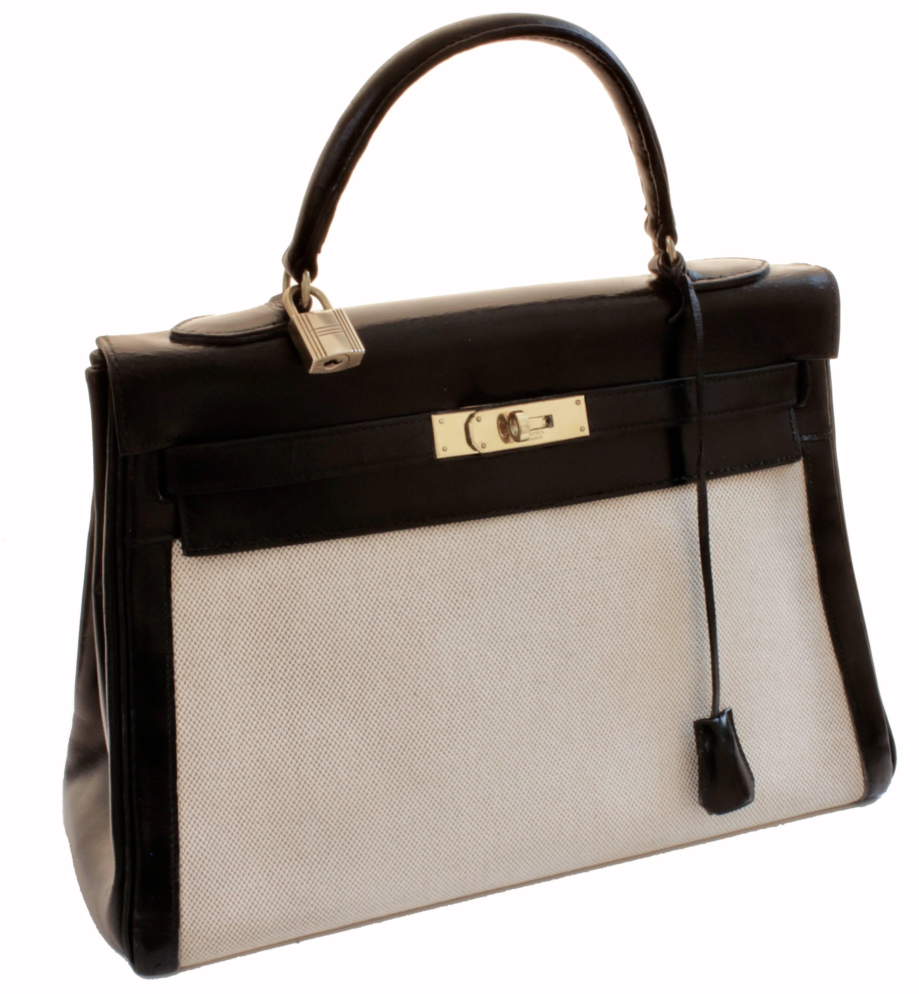 Ce fabuleux sac à main a été fabriqué par Hermès en 1949.  Initialement appelé Sac a Depeches:: ce sac est maintenant connu sous le nom de Sac Kelly et est fabriqué en cuir Gulliver noir et en toile.  Il est doublé en cuir de chèvre noir et:: comme