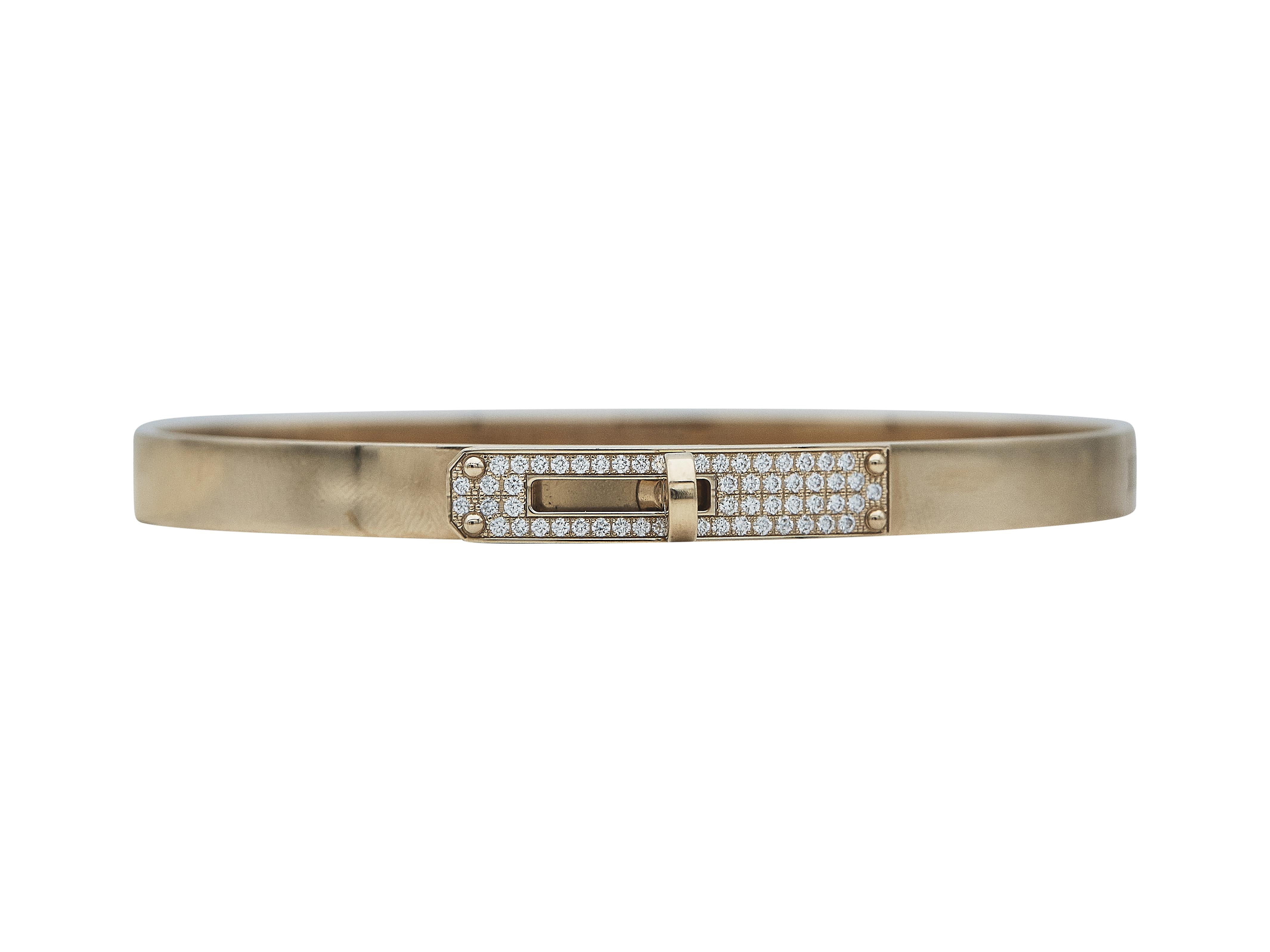 The bracelet: An Hermès Kelly bangle bracelet. This Small model is a size large, which accommodates a 17 cm wrist. It is designed in eighteen karat rose gold and set with round brilliant cut diamonds.

The bracelet is in excellent condition, with