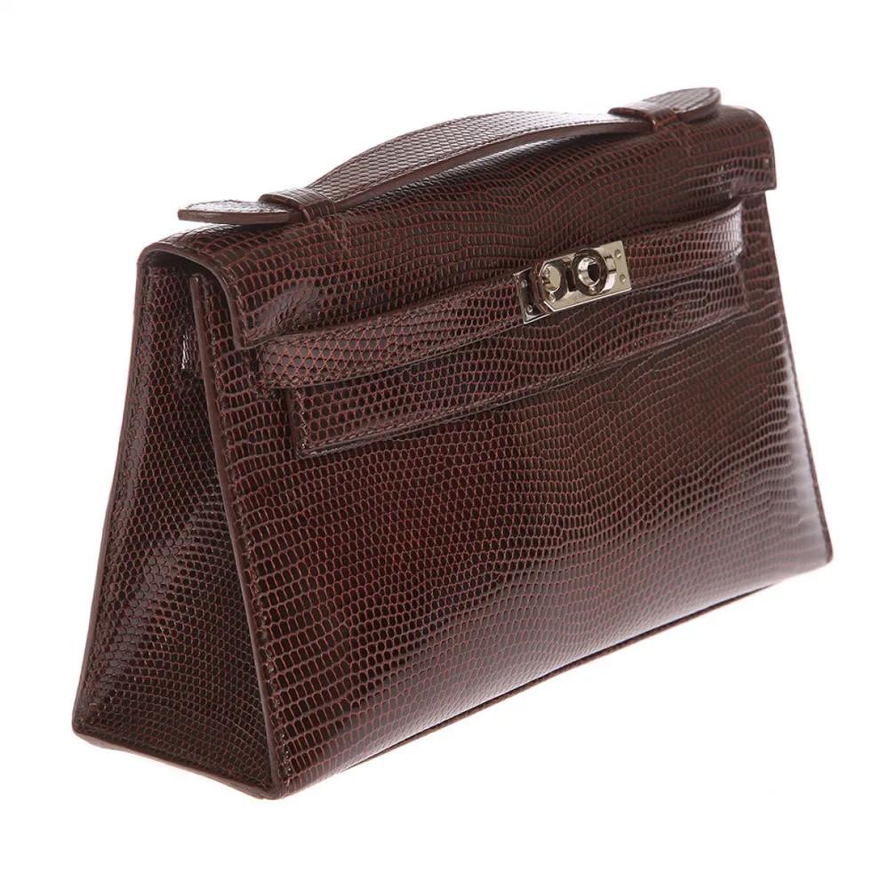 Hermès Kelly pochette brown lizard 
2007 Kelly in brown lizard leather, silver tone hardware in perfect condition for its age. Shows just some slight prints in the inside. It comes witupot invoice and cites.
Marked letter: K in a