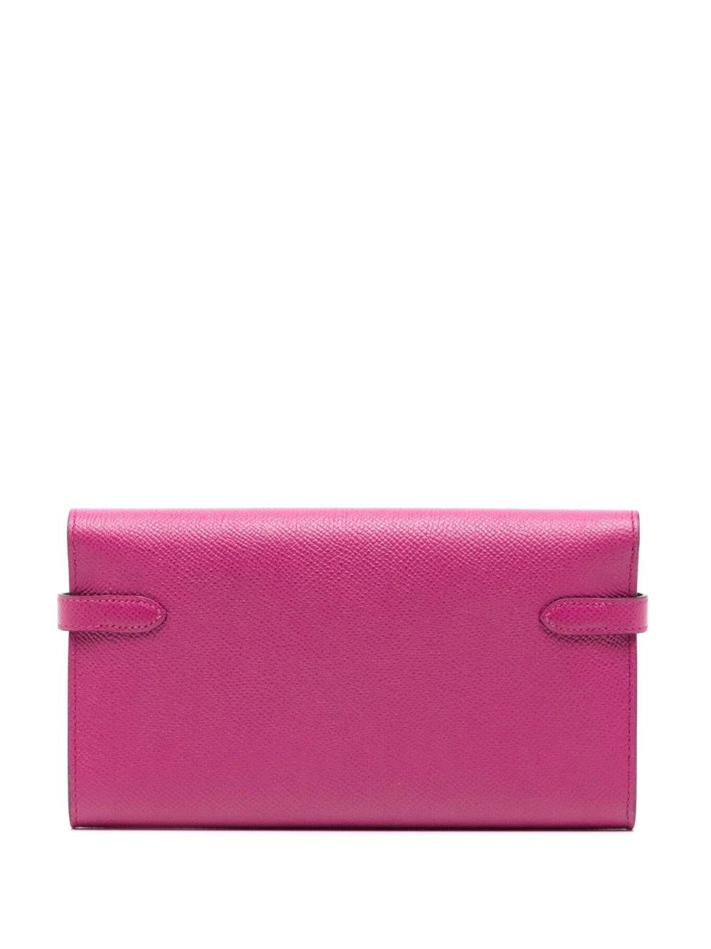 This Kelly Classic Wallet by Hermès is a timeless and elegant piece for your collection. It has been handcrafted in a magenta epsom leather and is in excellent condition. Featuring the iconic Hermès clasp and palladium hardware, this wallet can be