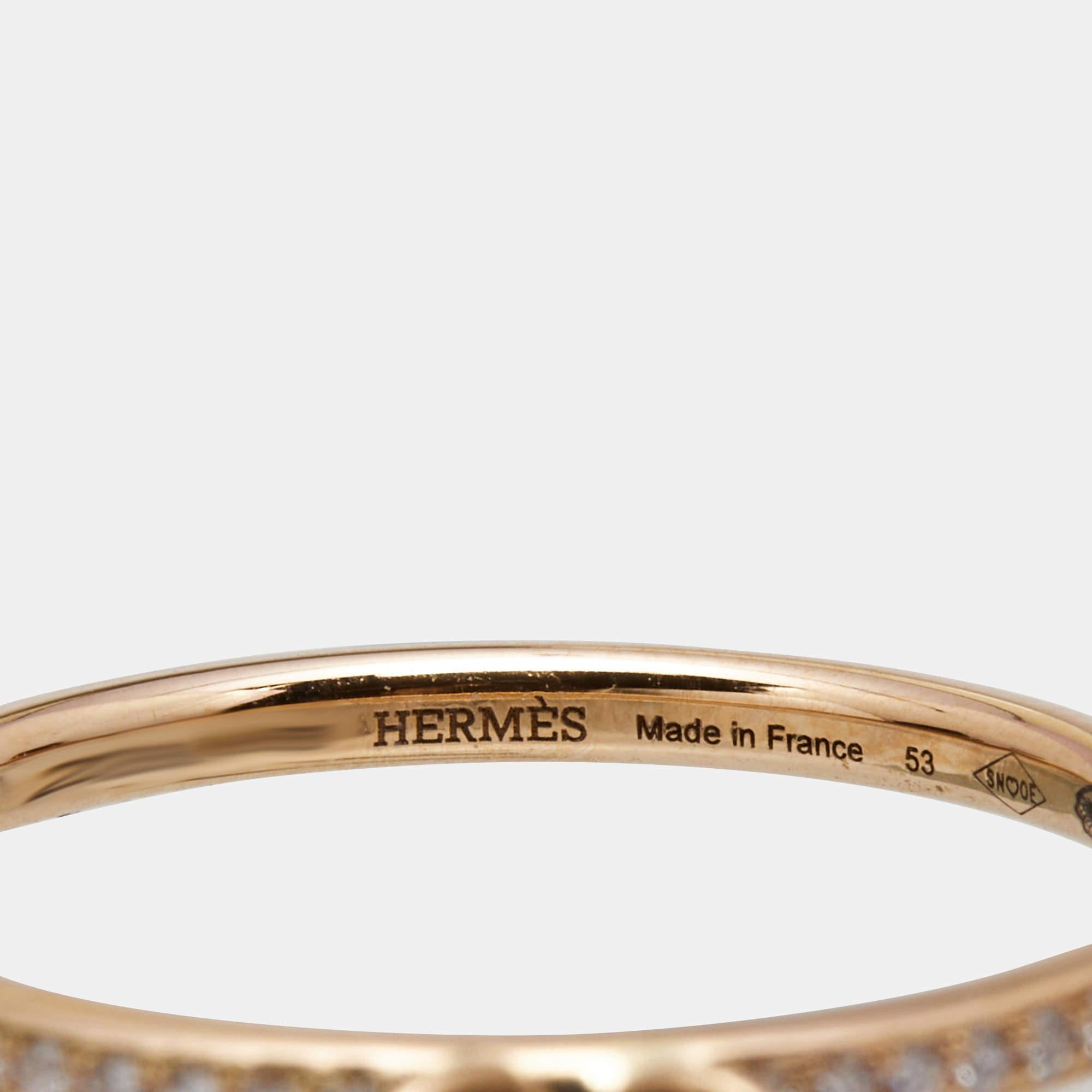 The Hermès ring exudes elegance and sophistication. Crafted with exquisite attention to detail, this captivating piece showcases a band of lustrous 18k rose gold adorned with a delicate clochette charm embellished with sparkling diamonds. A