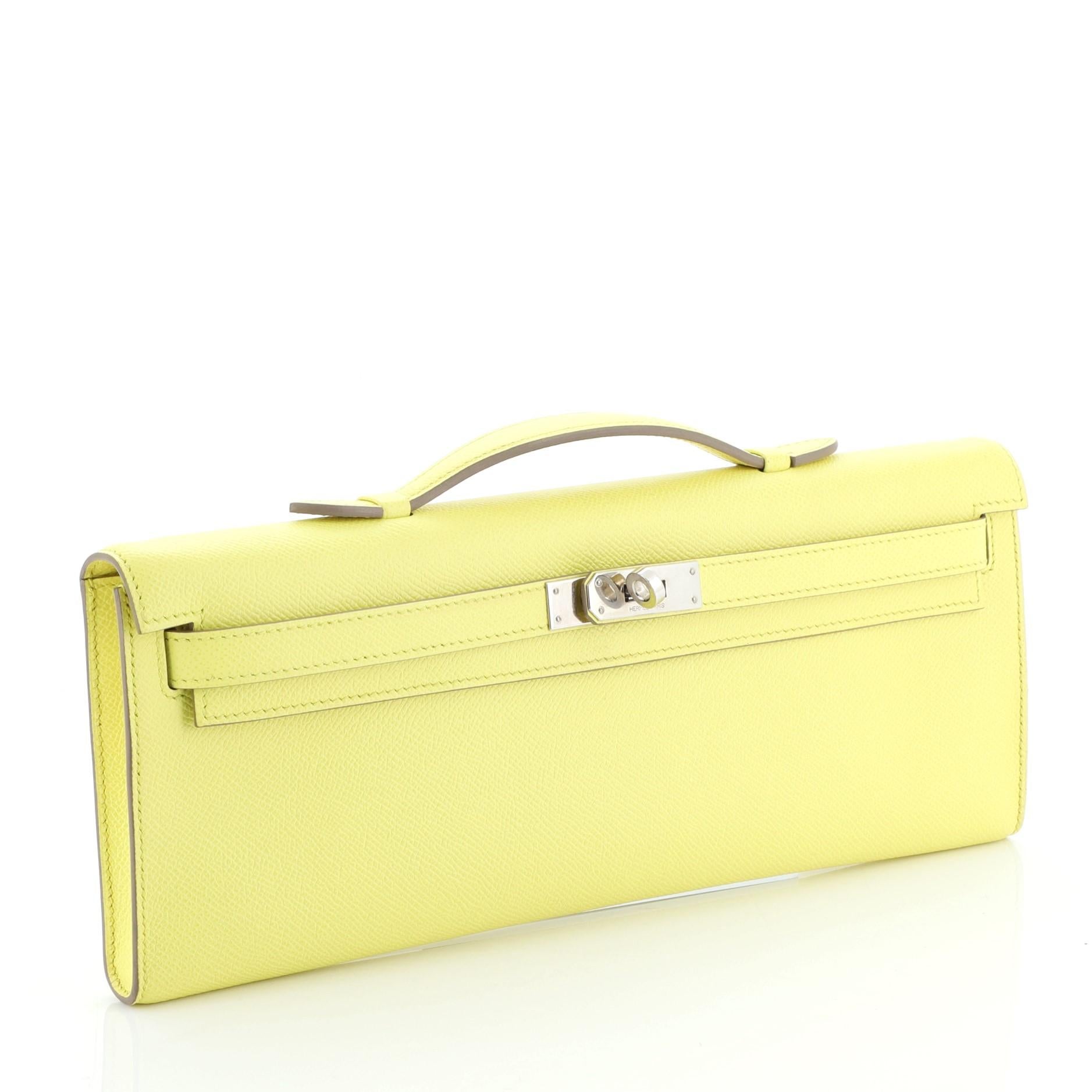 This Hermes Kelly Cut Pochette Epsom, crafted in Soufre yellow Epsom leather, features a frontal flap, top handle, and palladium hardware. Its turn-lock closure opens to a Soufre yellow Chevre leather interior. Date stamp reads: Q Square (2013).