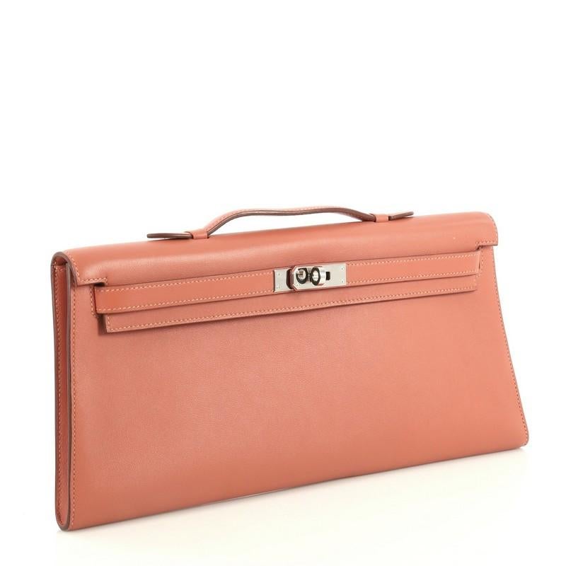 This Hermes Kelly Longue Handbag Swift, crafted in Rosy pink Swift leather, features a top handle, frontal flap, and palladium hardware. Its turn-lock closure opens to a Rosy pink Swift leather interior. Date stamp reads: L Square (2008). These are