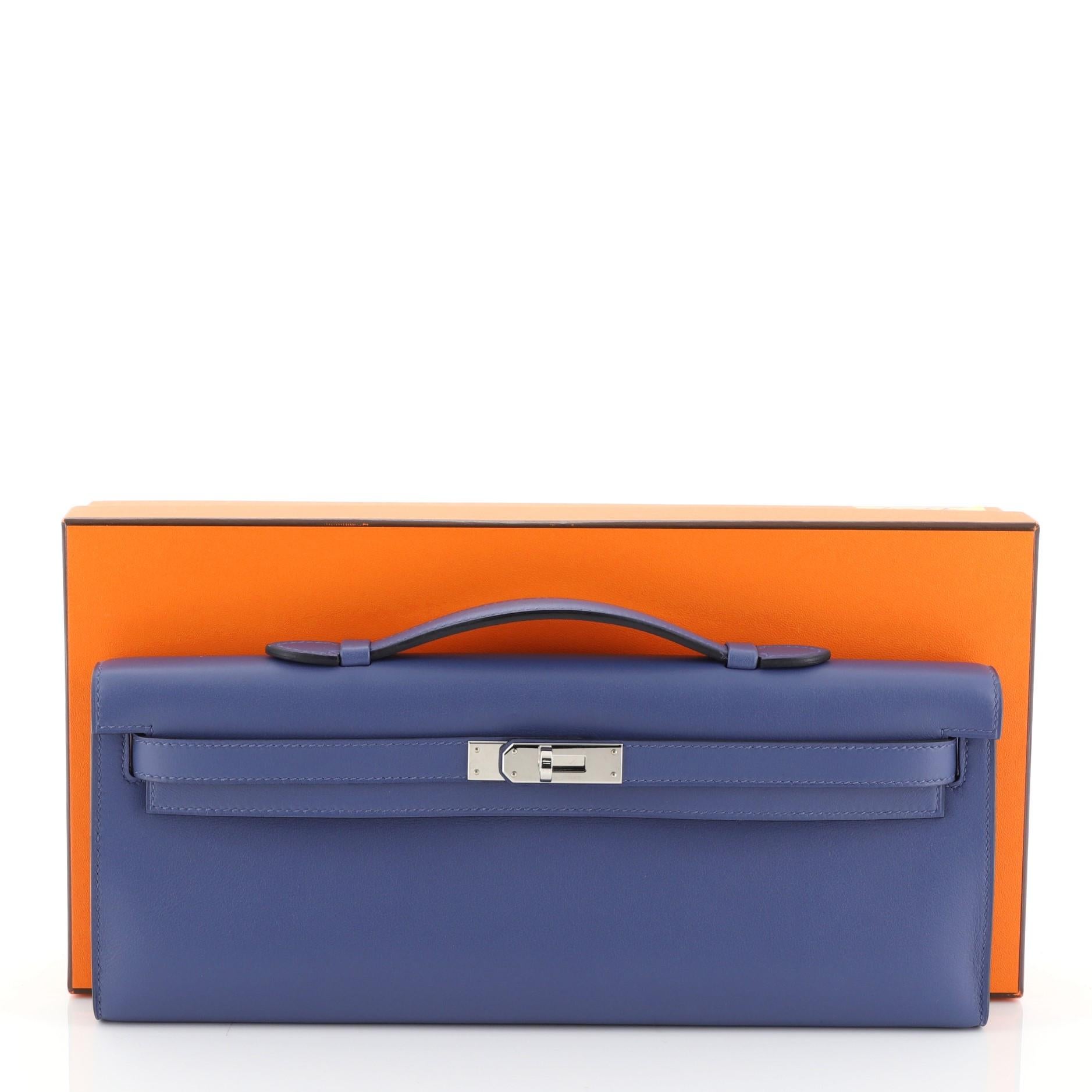 This Hermes Kelly Cut Pochette Swift, crafted in Bleu Brighton blue Swift leather, features a top handle, frontal flap, and palladium hardware. Its turn-lock closure opens to a Bleu Brighton blue Swift leather interior. Date stamp reads: A (2017).