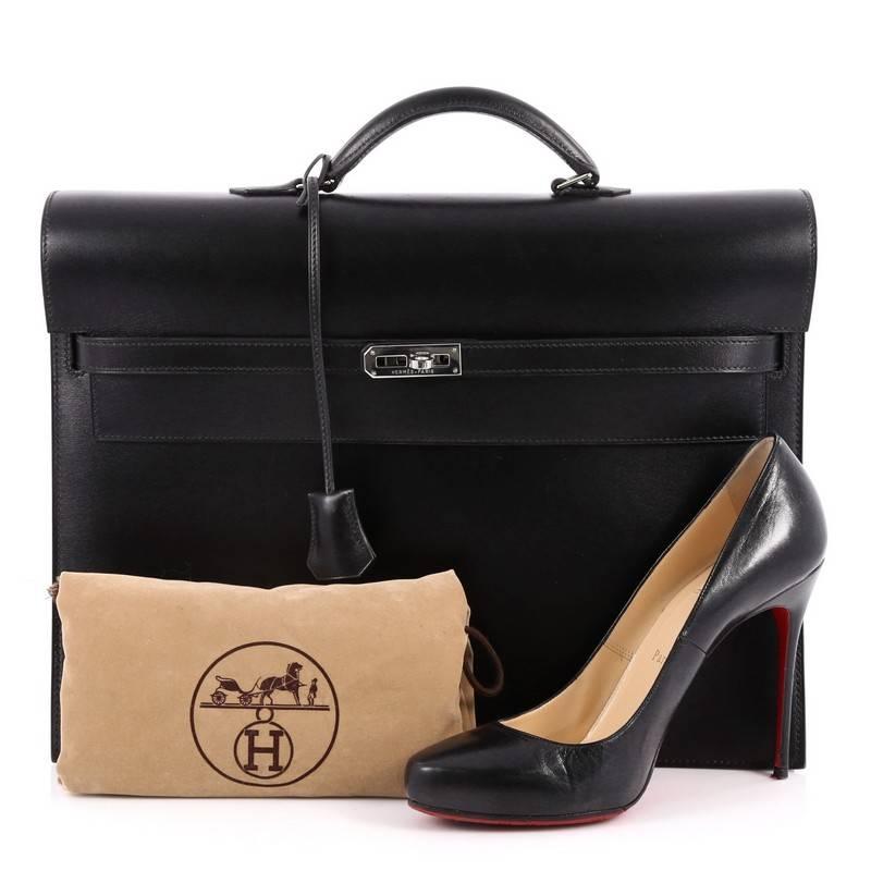 This authentic Hermes Kelly Depeche Handbag Box Calf 38 borrows its classic design from the brand's iconic Kelly bag. Crafted from sleek black box calf leather, this elegant briefcase features a short rolled top handle, accordion-like side gussets,