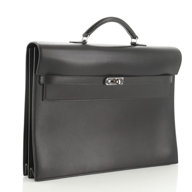 This Hermes Kelly Depeche Handbag Box Calf 38, crafted in Noir black Box Calf leather, features a single top handle, frontal flap, and palladium hardware. Its turn-lock closure opens to a Noir black raw leather interior. Date stamp reads: F Square
