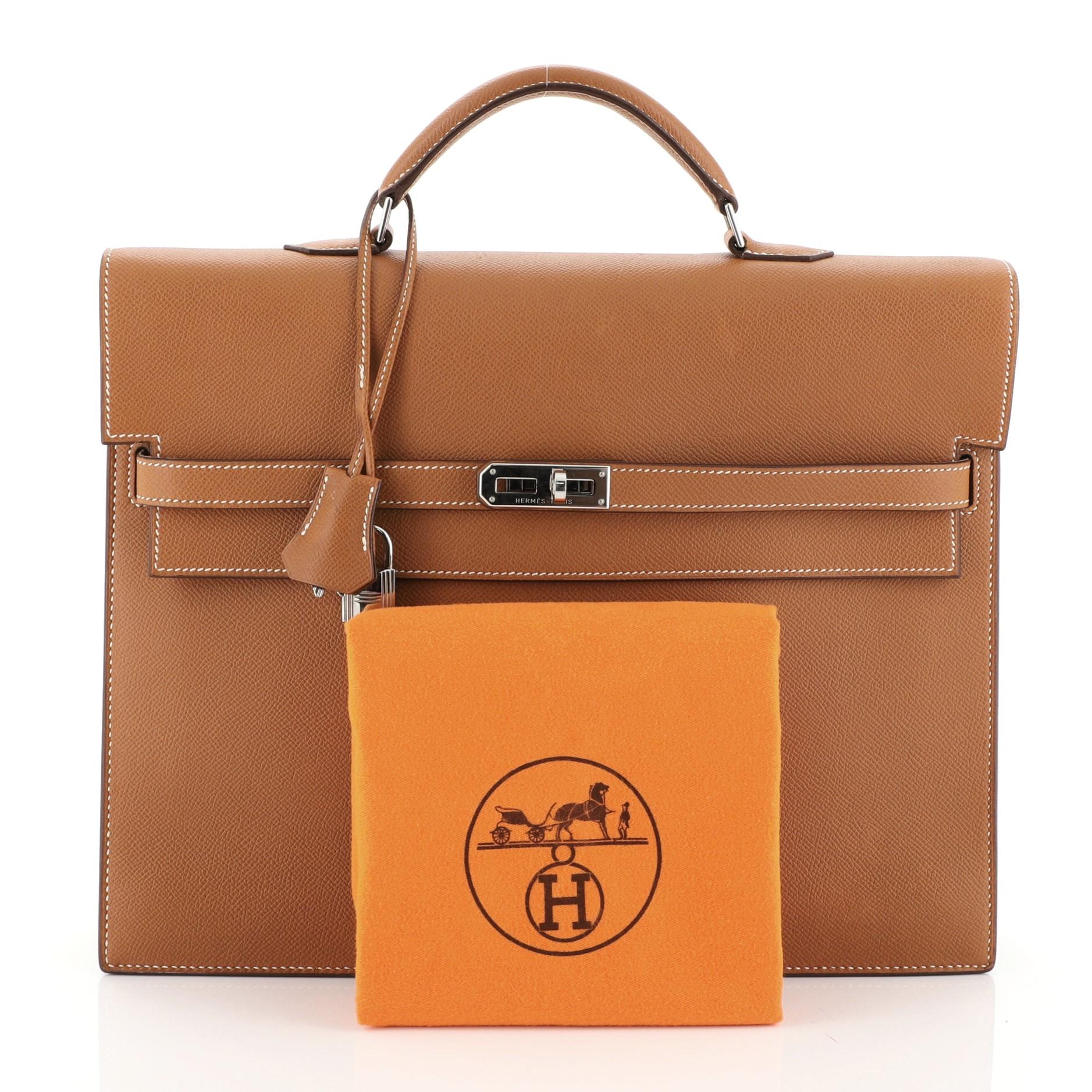 This Hermes Kelly Depeche Handbag Epsom 34, crafted in Cognac brown Epsom leather, features a single top handle, frontal flap, and palladium hardware. Its turn-lock closure opens to a Cognac brown raw leather interior. Date stamp reads: J Square