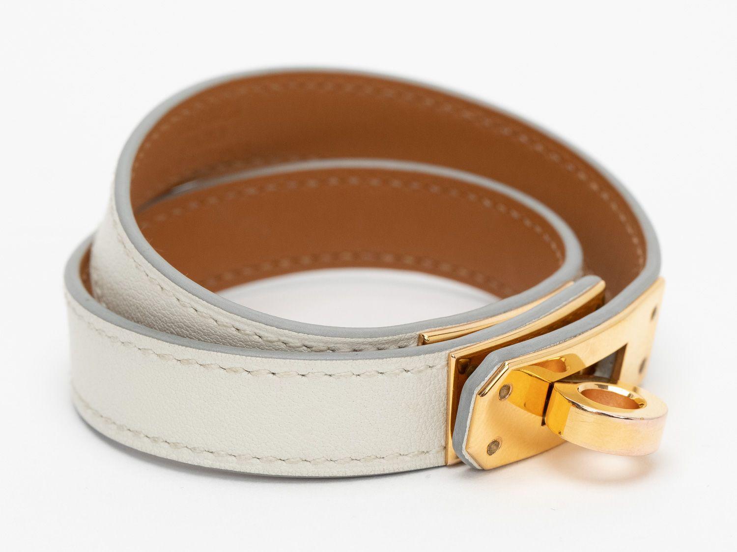 Hermès Kelly Double Tour bracelet in the color nata. Calfskin white leather and gold hardware. The date stamp shows a C, size small. Comes with a velvet pouch.