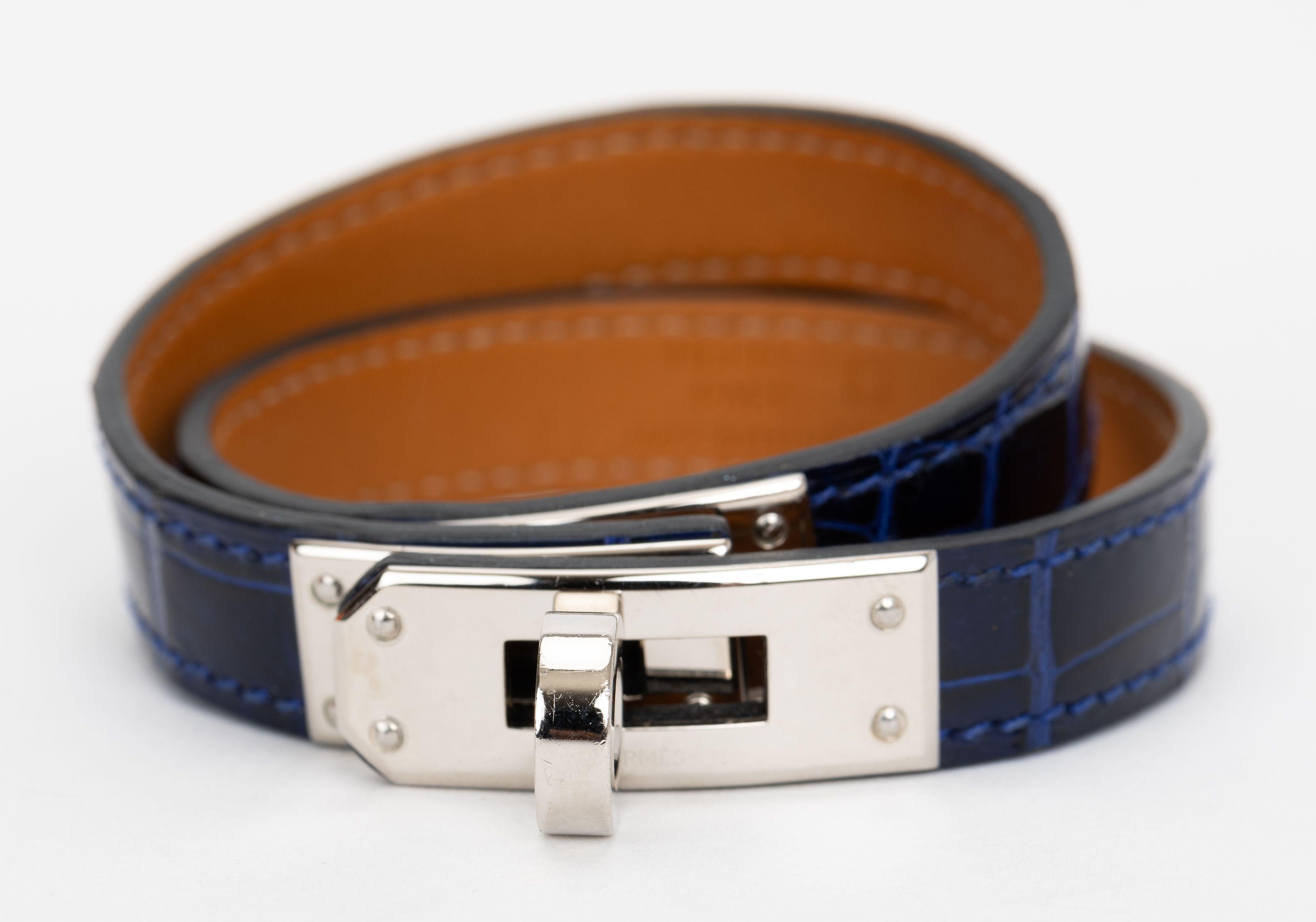 La pulsera Hermes Kelly Double Tour, de piel de cocodrilo azul y herrajes paladio, incorpora el característico cierre giratorio Kelly. Talla pequeña. Sello de fecha A. Viene con caja original.