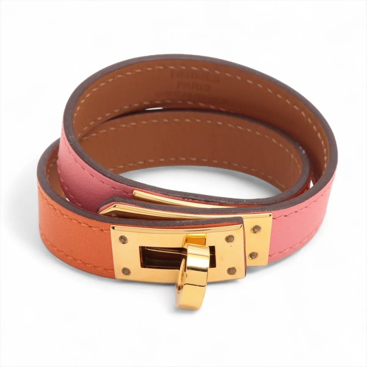 La Pulsera Hermès Kelly Double Tour Bicolor Rosa Azalée y Naranja es una expresión chic y contemporánea del estilo icónico de la marca. Fabricado en fina piel, envuelve elegantemente dos veces la muñeca, creando un sofisticado look a capas. La