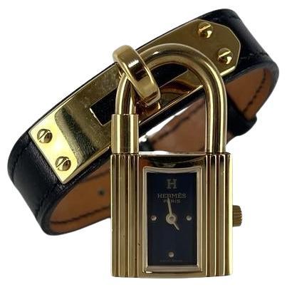 Orologio Hermès Kelly placcato oro con cinturino in pelle nera in vendita