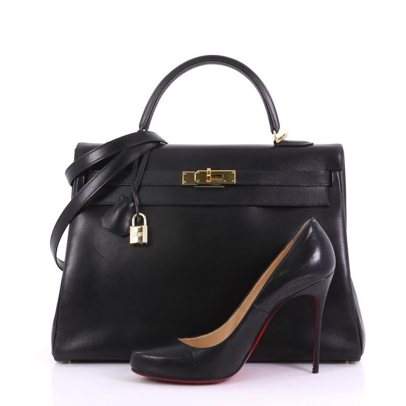 This Hermes Kelly Handbag Black Box Calf with Gold Hardware 35, crafted in Noir Black box calf leather, features a single rolled top handle, protective base studs, and gold hardware. Its turn-lock closure opens to a Noir black Chevre leather