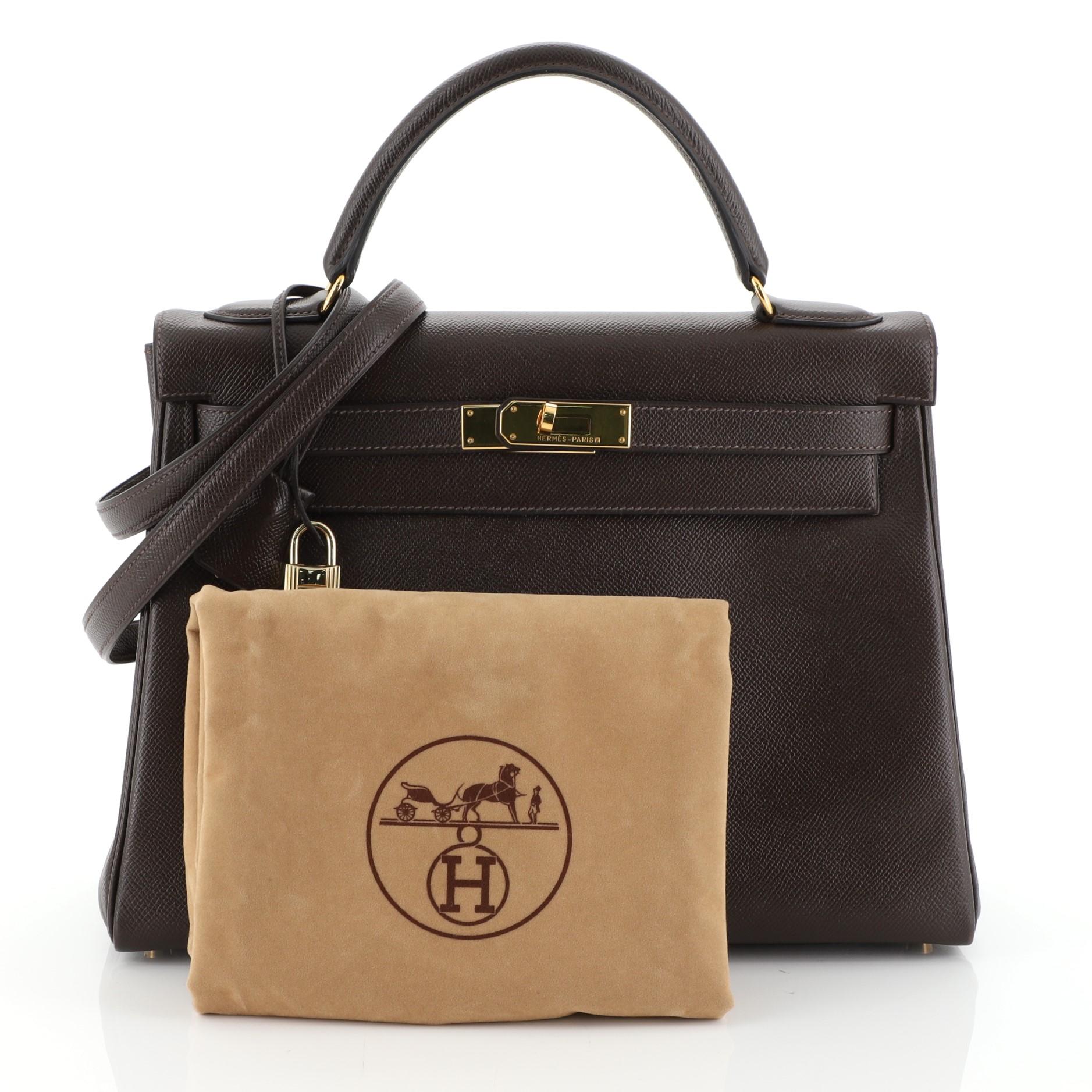This Hermes Kelly Handbag Chocolate Courchevel with Gold Hardware 32, crafted from Chocolate brown Courchevel leather, features a single top handle and gold hardware. Its turn-lock closure opens to a Chocolate brown Chevre leather interior with zip