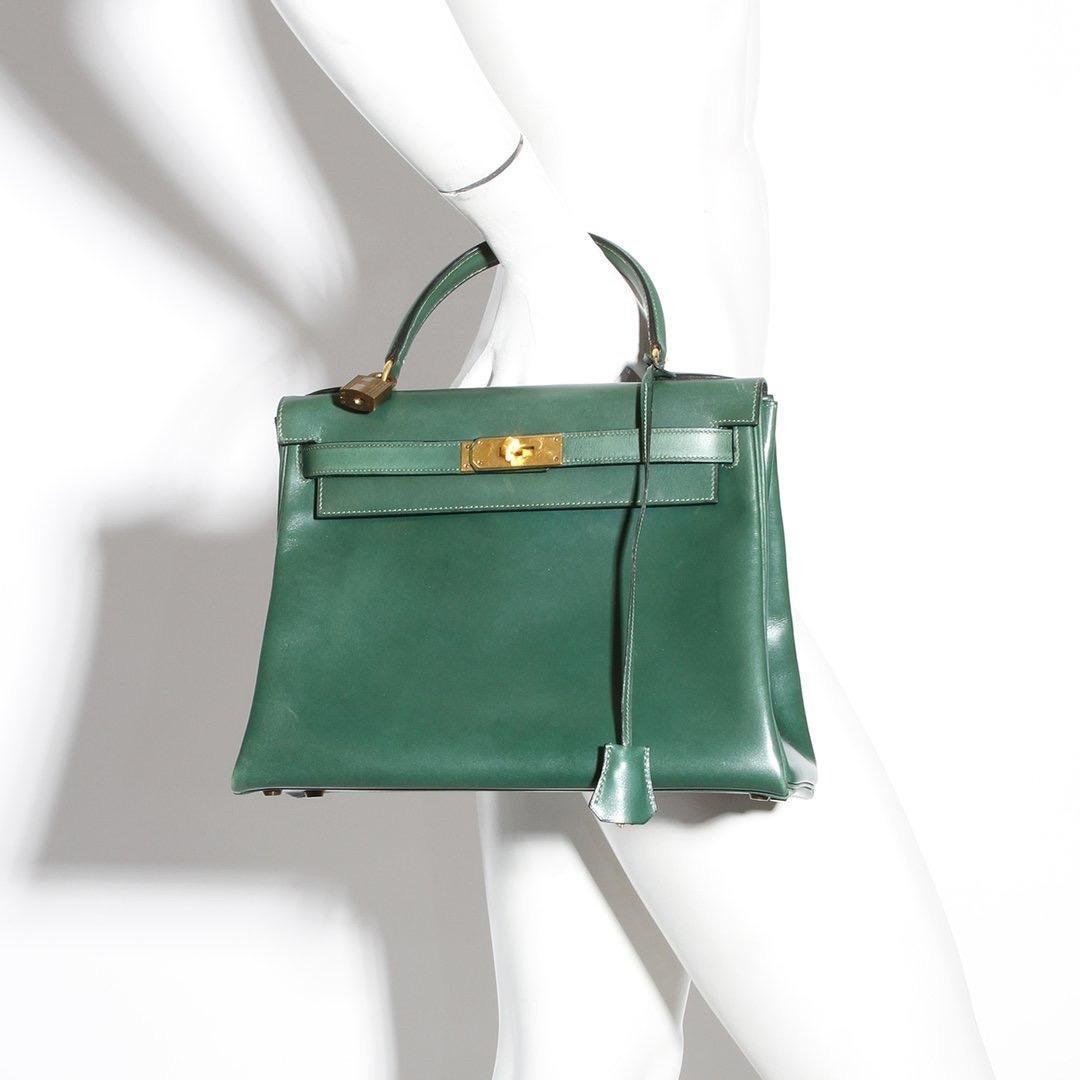 Kelly handbag by Hermes 
Circa 1973
Green leather
Gold-tone Hardware 
Feet on bottom 
Two interior slip pockets 
One interior zip pocket 
Kelly style with top handle
Comes with lock and key 
Comes with dustbag
Condition: Excellent vintage condition,